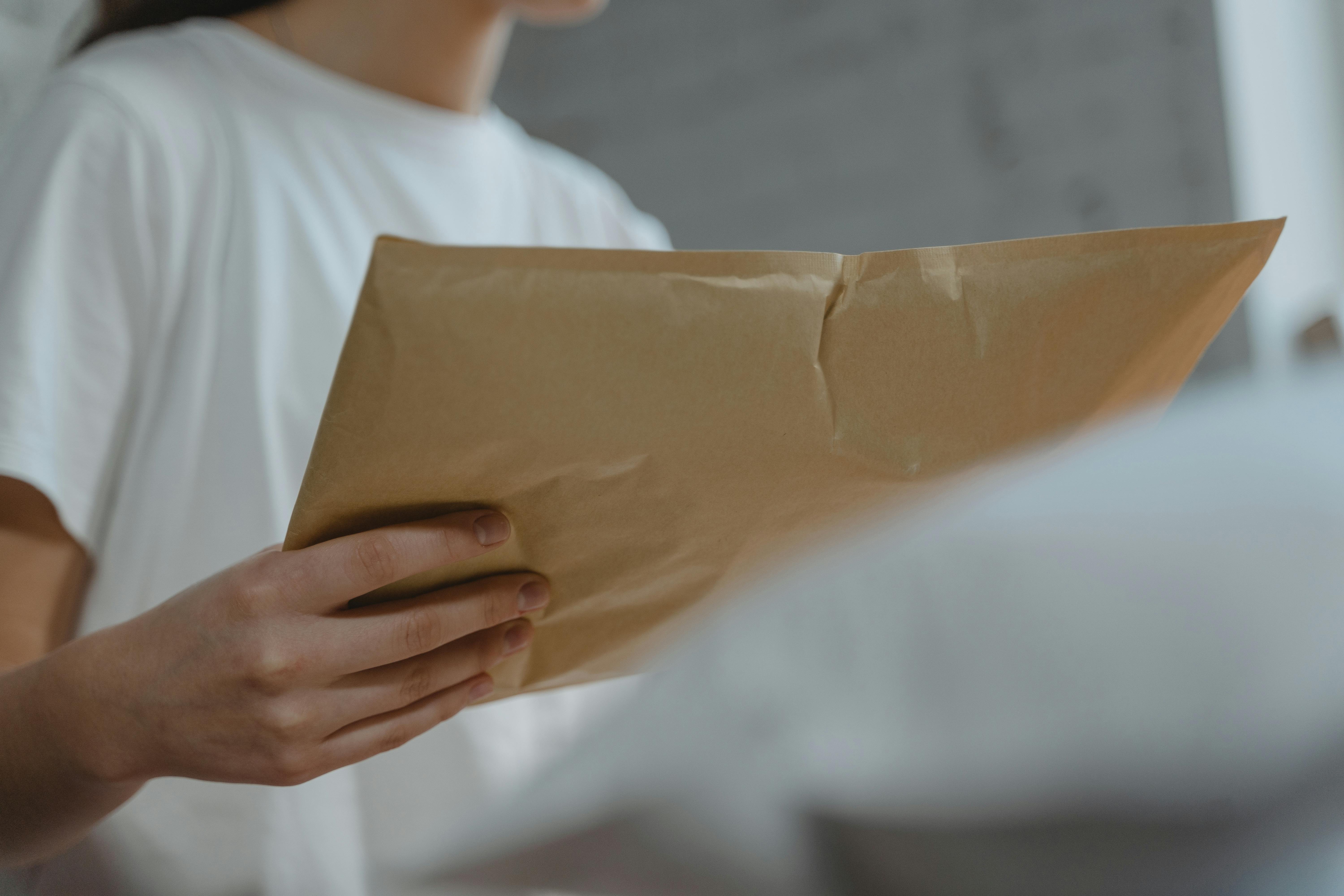 A woman holding an envelope | Source: Pexels