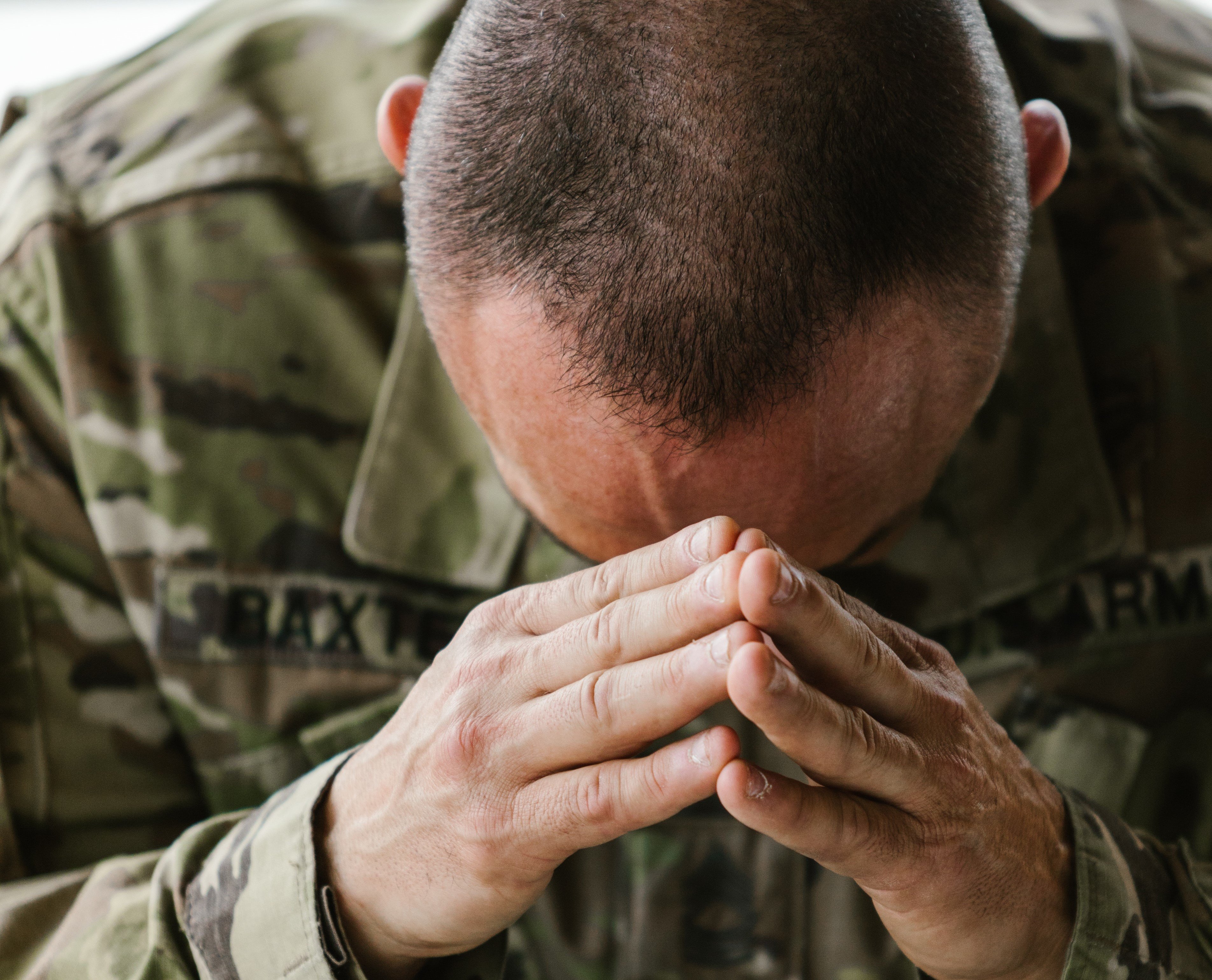 Soldado oculta la cabeza entre las manos. | Foto: Pexels