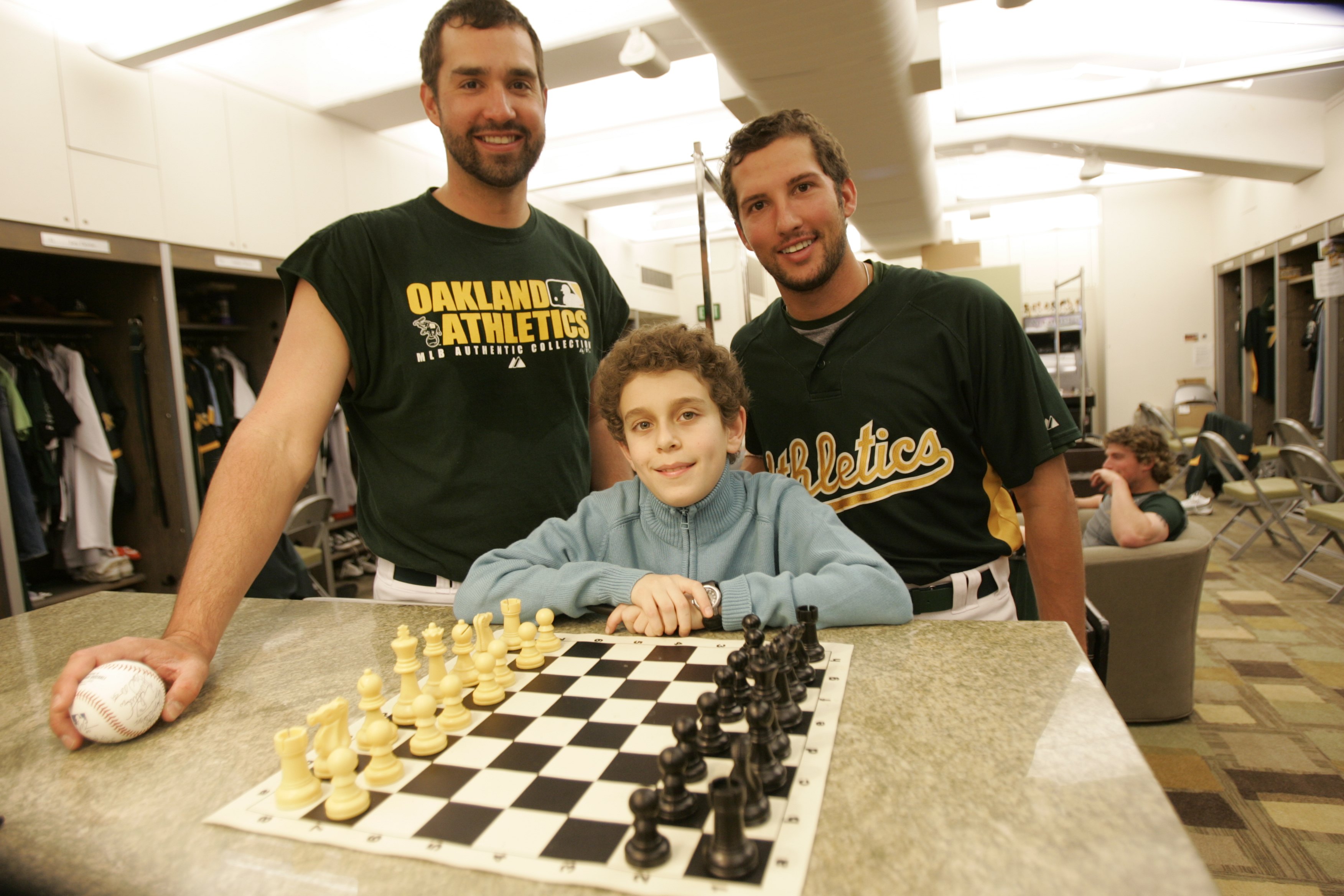 Chess champion Daniel Naroditsky meets Andrew Brown and Huston Street of the Oakland Athletics in the clubhouse before the game against the Minnesota Twins at McAfee Coliseum in Oakland, California on April 23, 2008. | Source: Getty Images