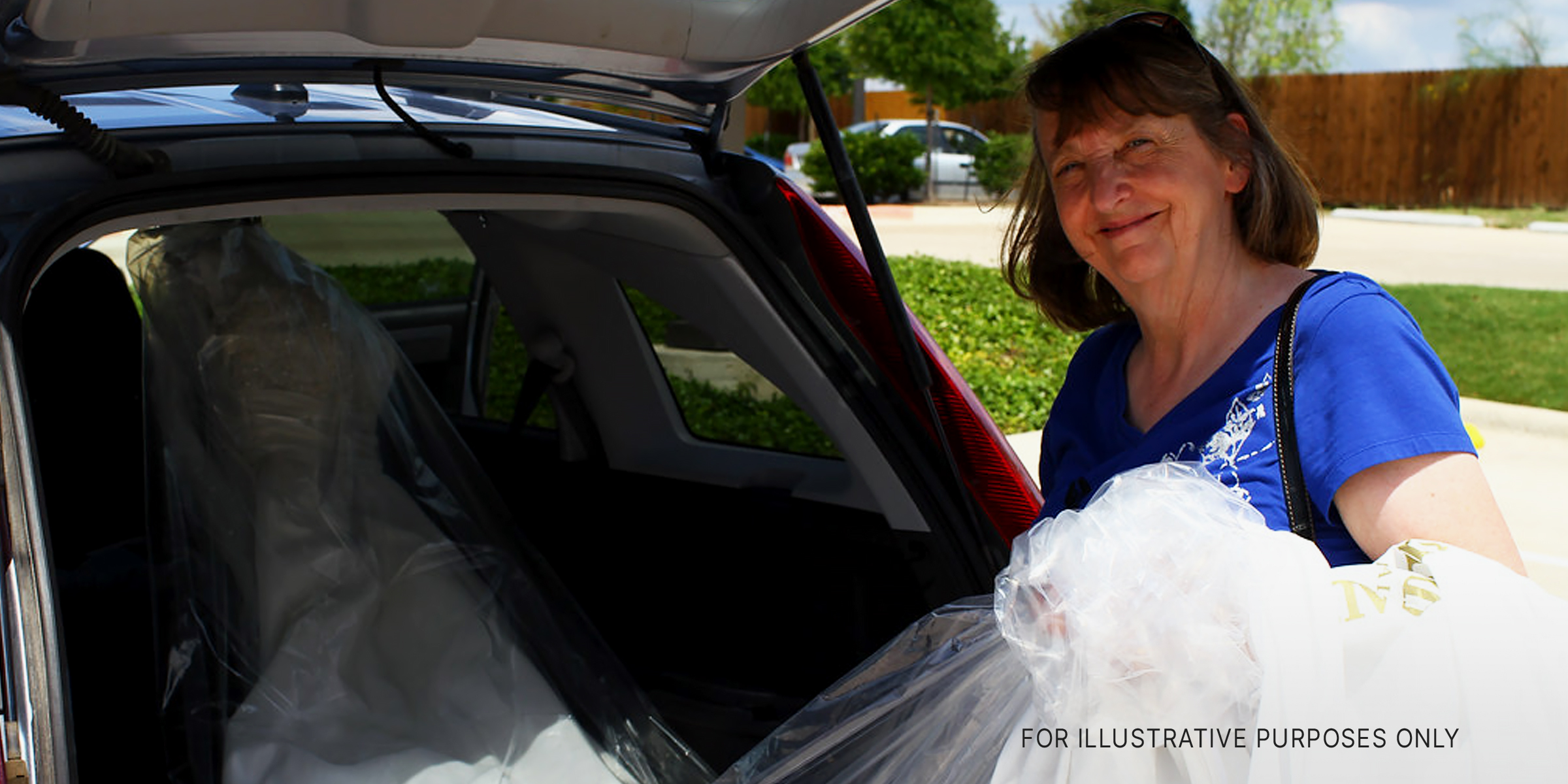 An elderly woman taking out a bridal dress from her car's trunk | Source: Flickr/waitscm/CC BY 2.0