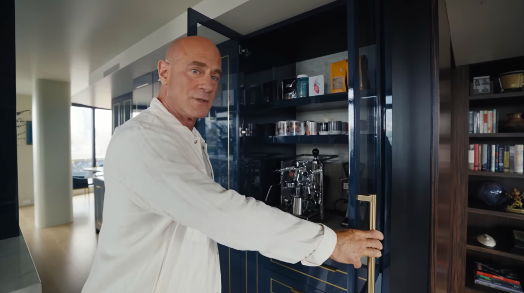 Christopher jokingly crowned this concealed coffee station the most important room in the house. The espresso setup disappears neatly behind the same glossy cabinetry used throughout the kitchen. | Source: YouTube/Architectural Digest