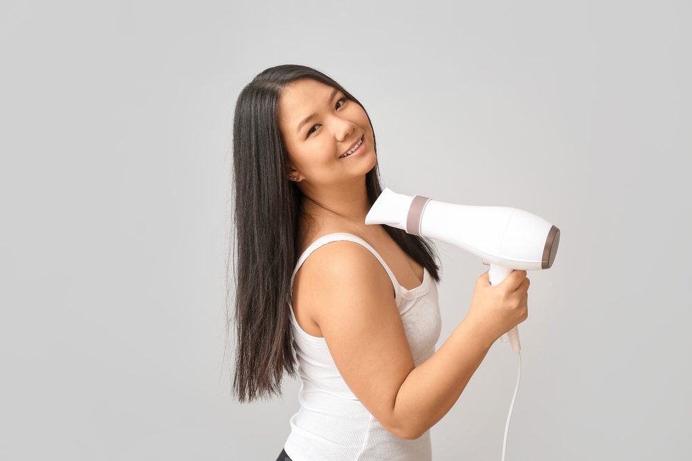 Mujer con secador de pelo en la mano. | Foto: Shutterstock