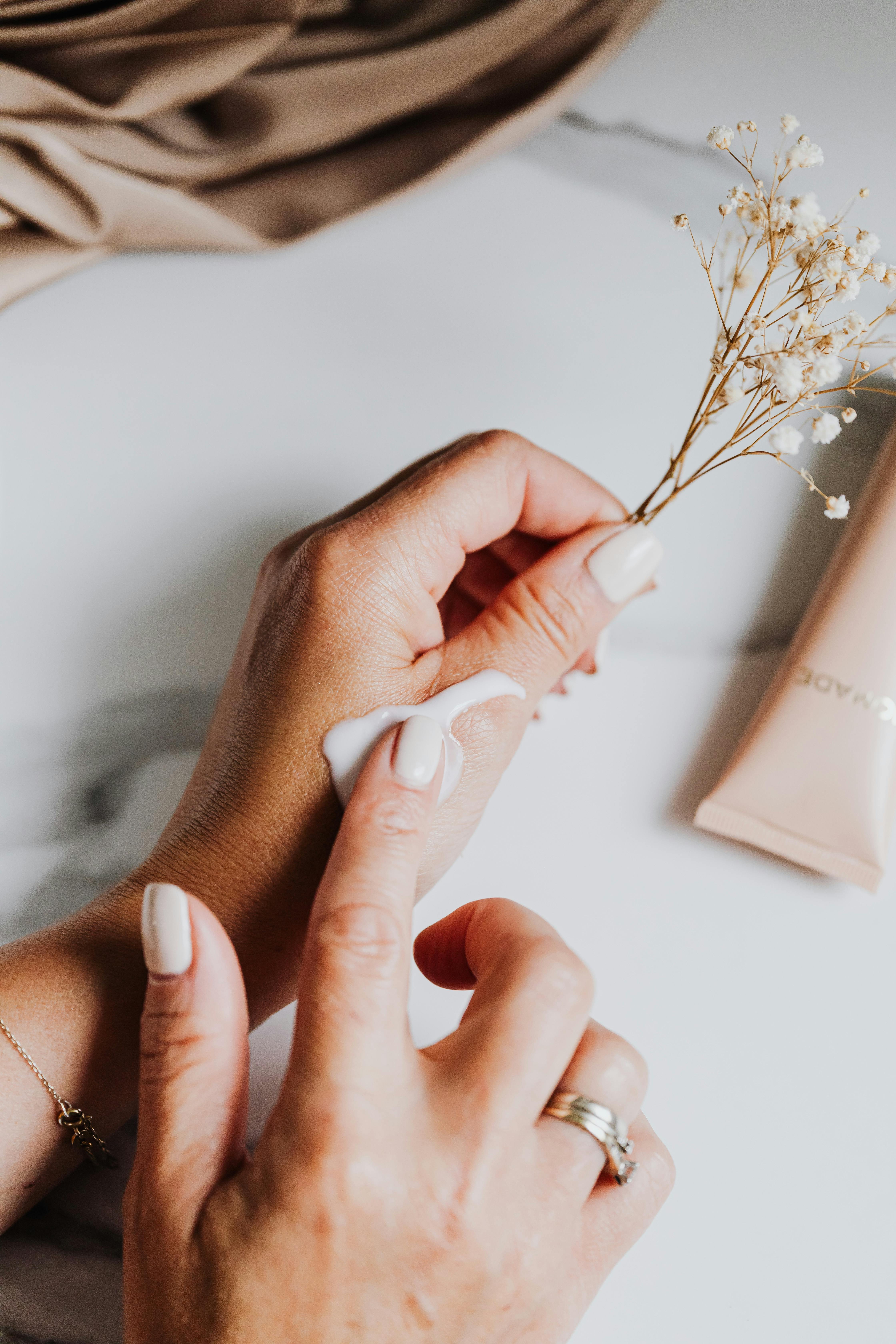 A woman putting lotion on her skin | Source: Pexels