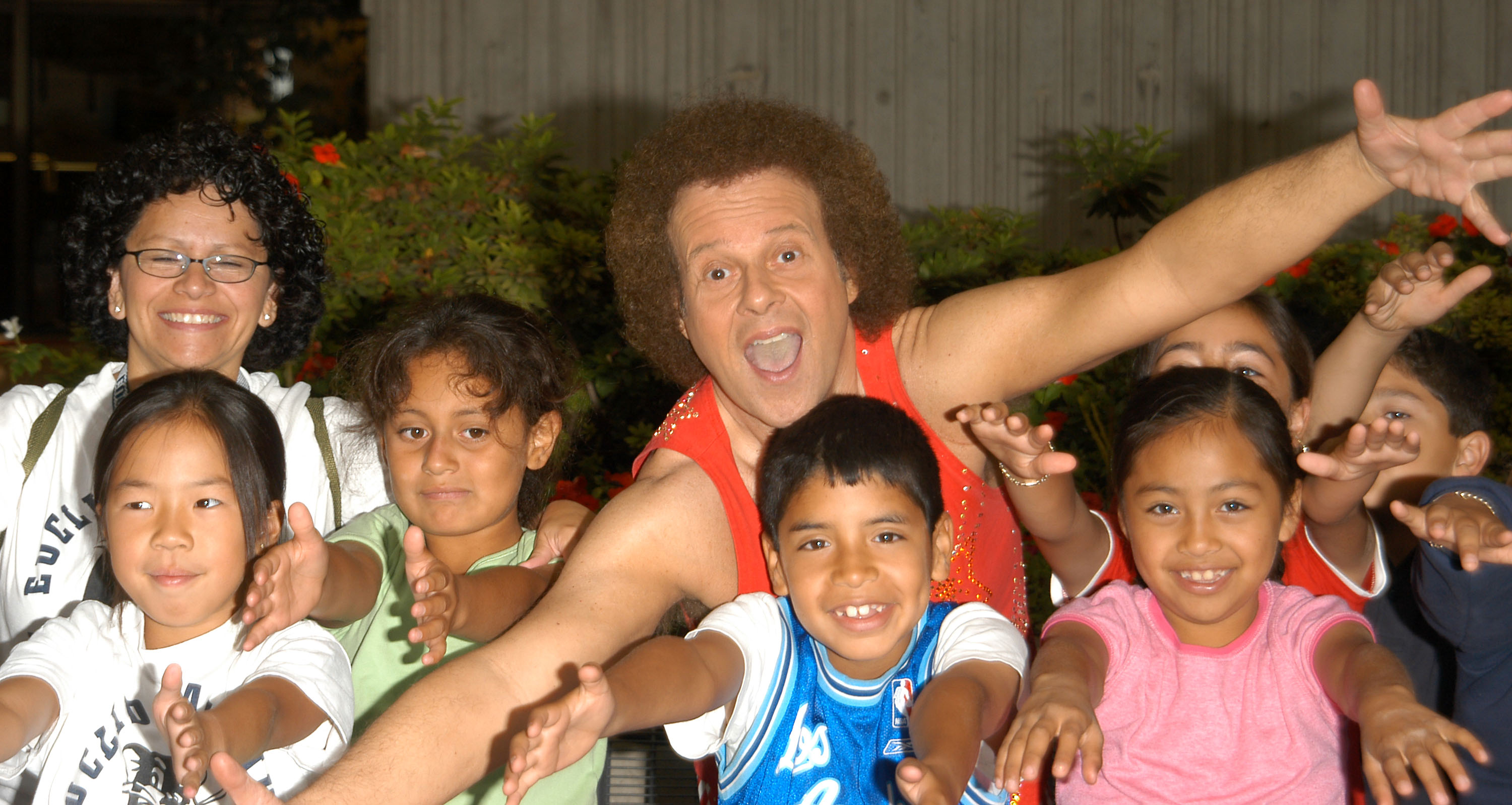 Richard Simmons poses with students at the Third Annual Nutrition Advisory Council Symposium at California State University in Los Angeles on June 16, 2004 | Source: Getty Images