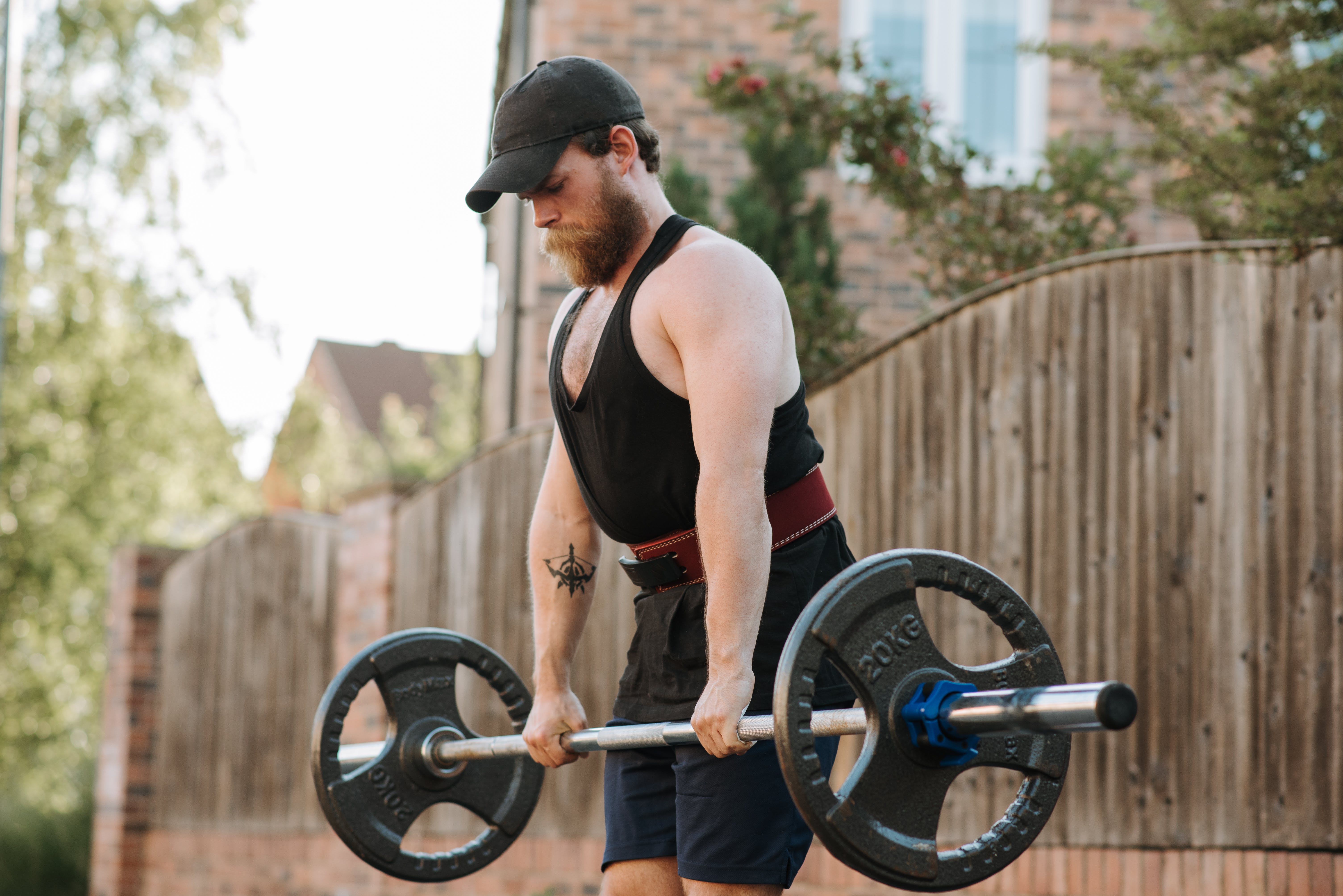 A man working out in the street with a barbell | Source: Pexels