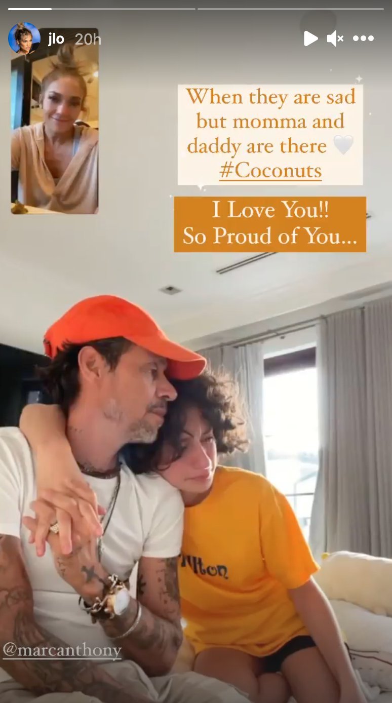 Marc Anthony abraza a su hija Emme, mientras Jennifer López observa a través de la pantalla. | Captura historias de Instagram/jlo. 