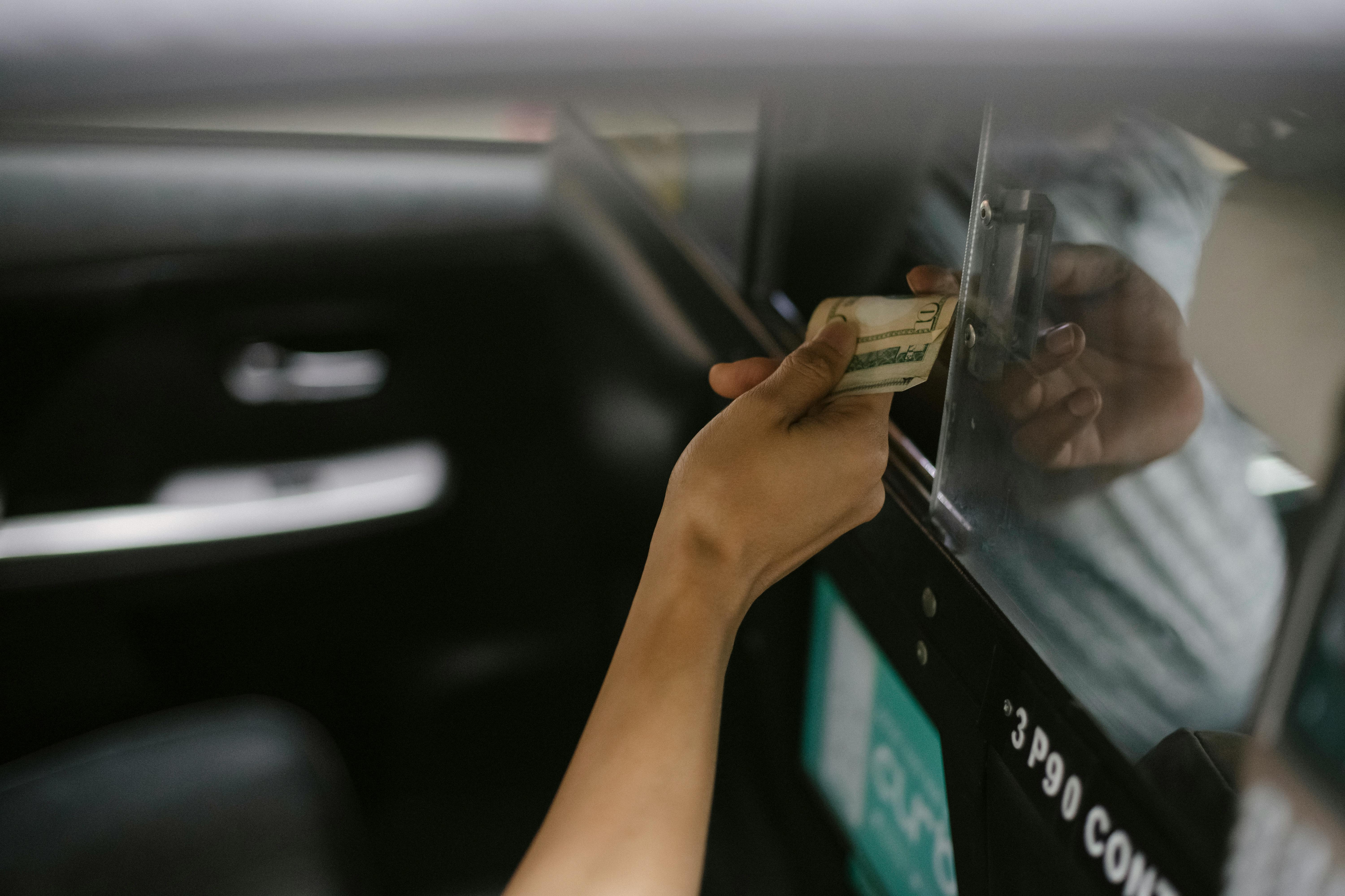 A woman passing money to taxi driver | Source: Pexels