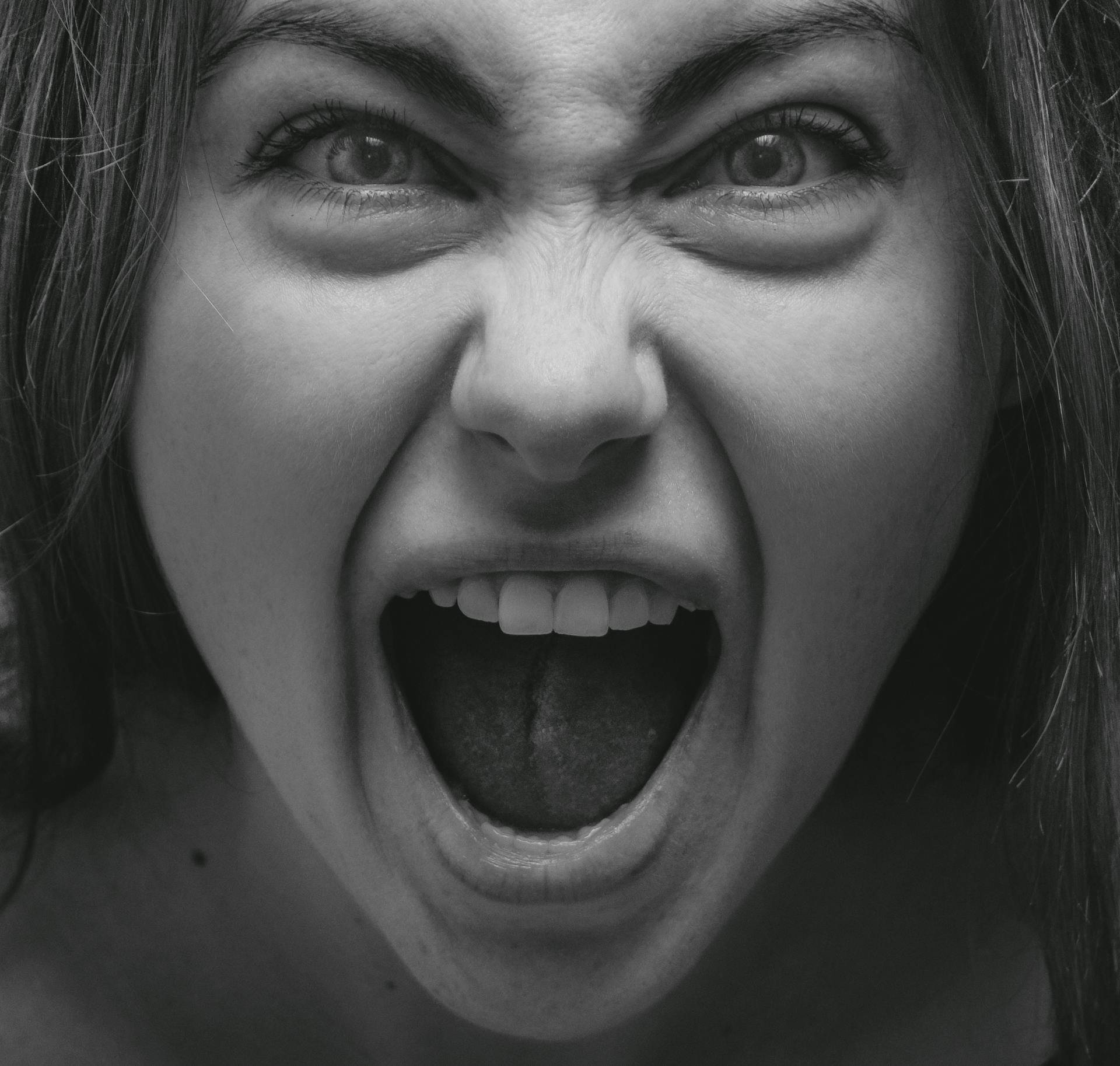 Grayscale close-up of an angry woman yelling | Source: Pexels