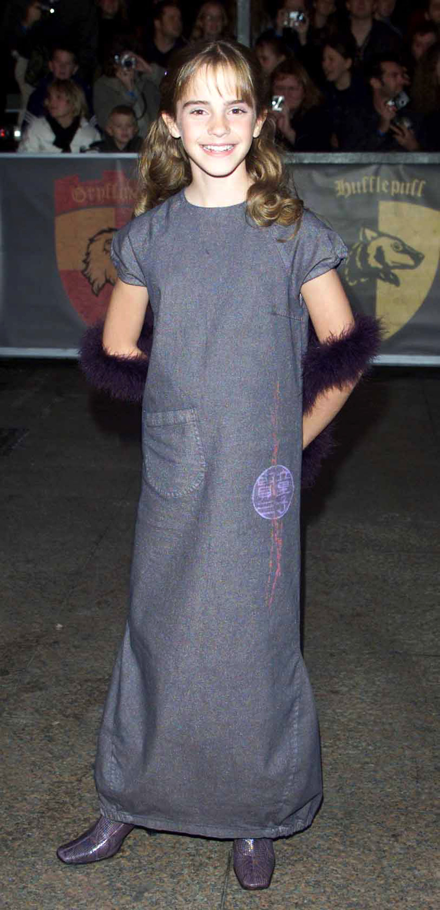 At just 11 years old, Watson made her red carpet debut in 2001 at the premiere of "Harry Potter and the Sorcerer's Stone." Dressed in a long gray gown with purple accents and matching boots, she wore her hair in curled pigtails with wispy bangs, radiating the charm of a young newcomer stepping into global fame as Hermione Granger.