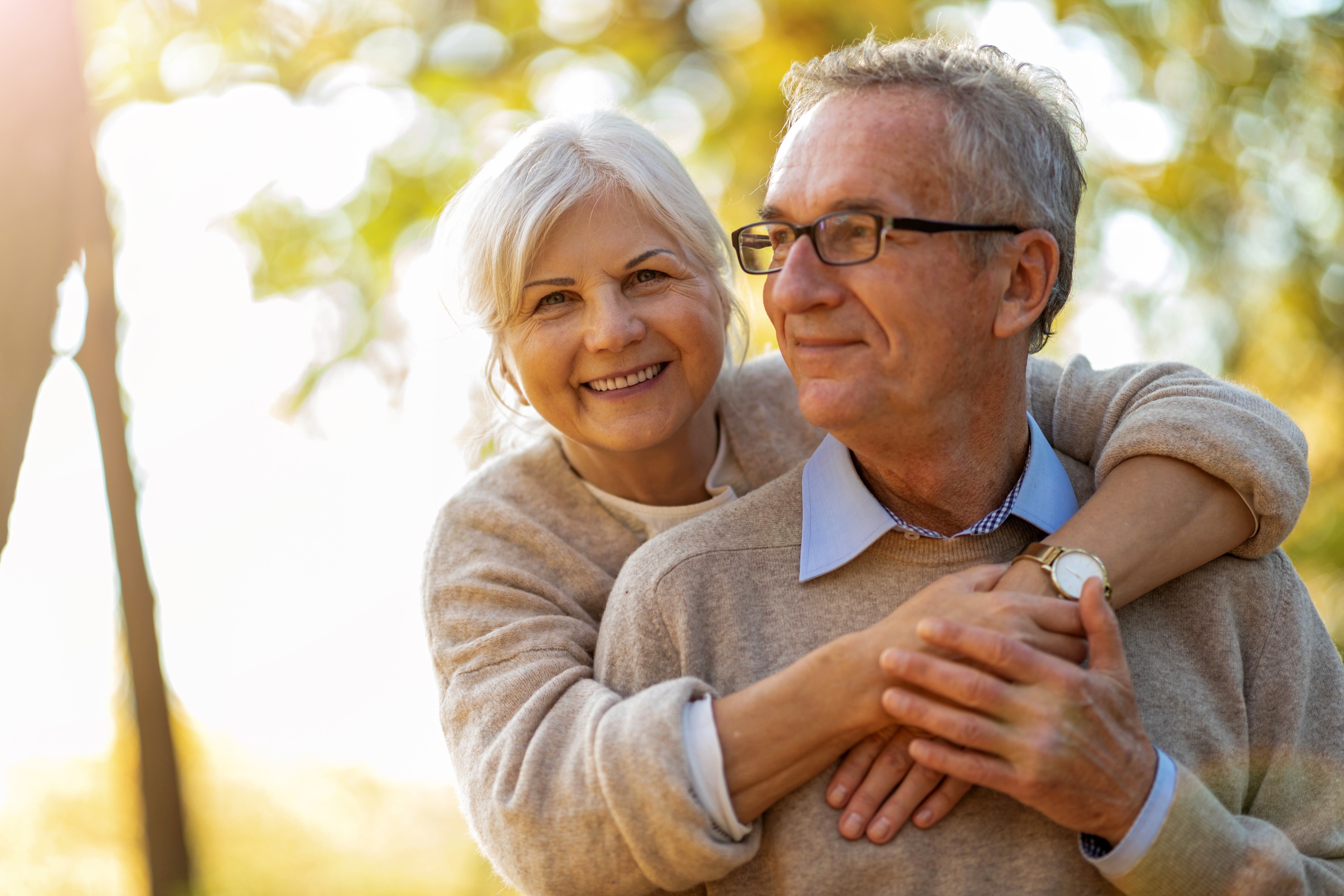 An elderly couple pictured hugging in a park | Source: Shutterstock