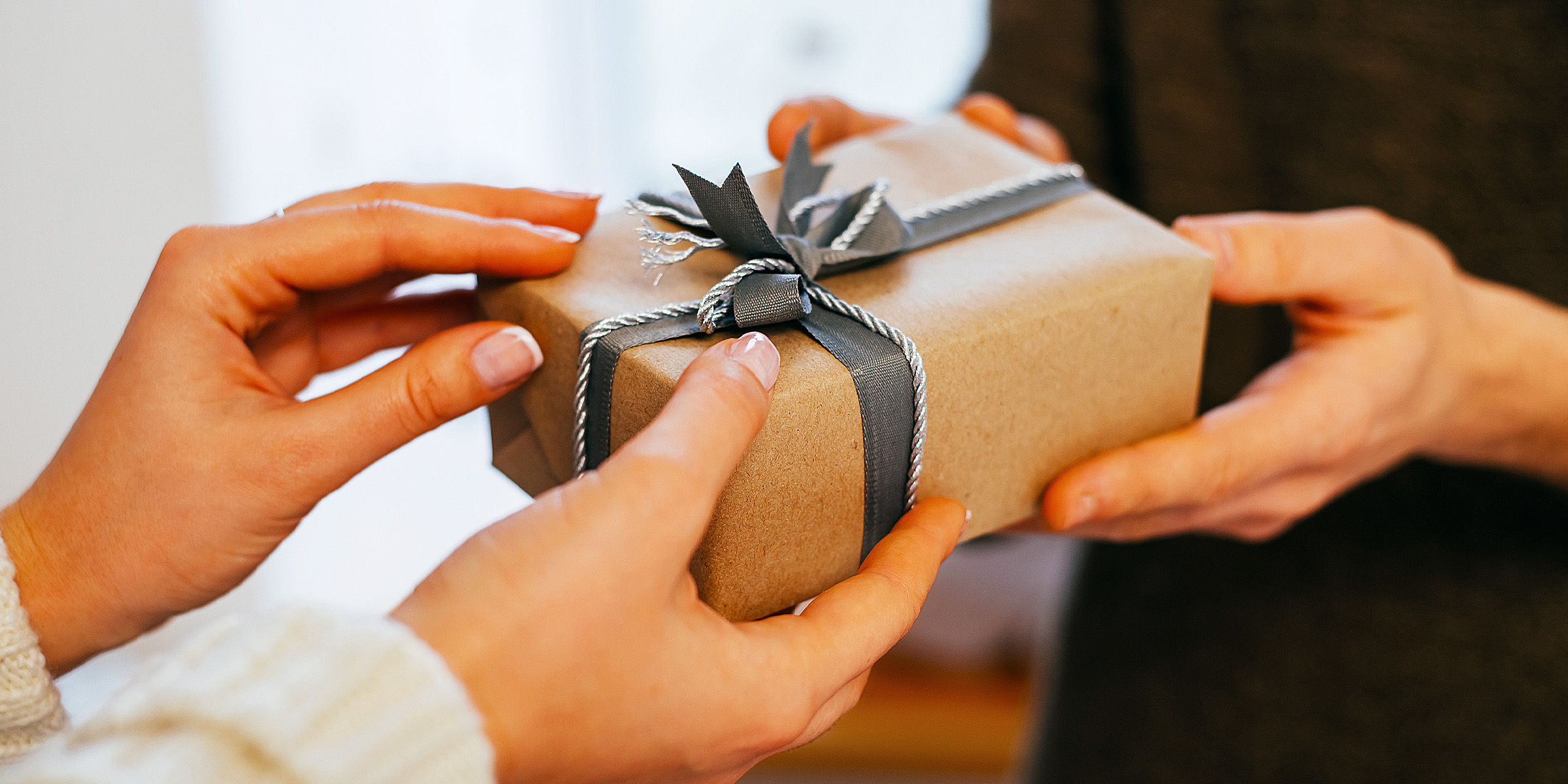 Two people holding a gift box | Source: Shutterstock