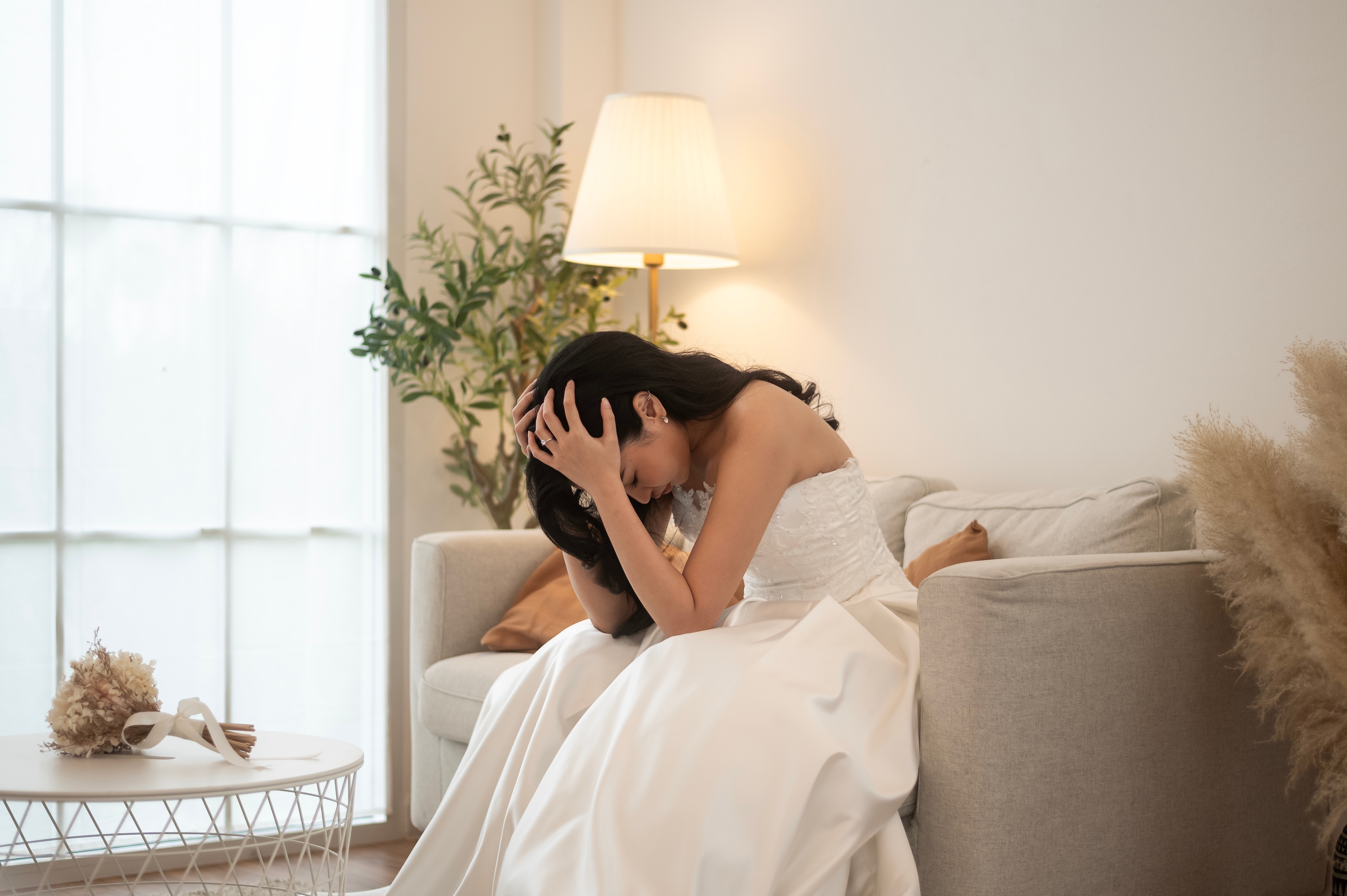 An upset bride sitting on a couch | Source: Shutterstock