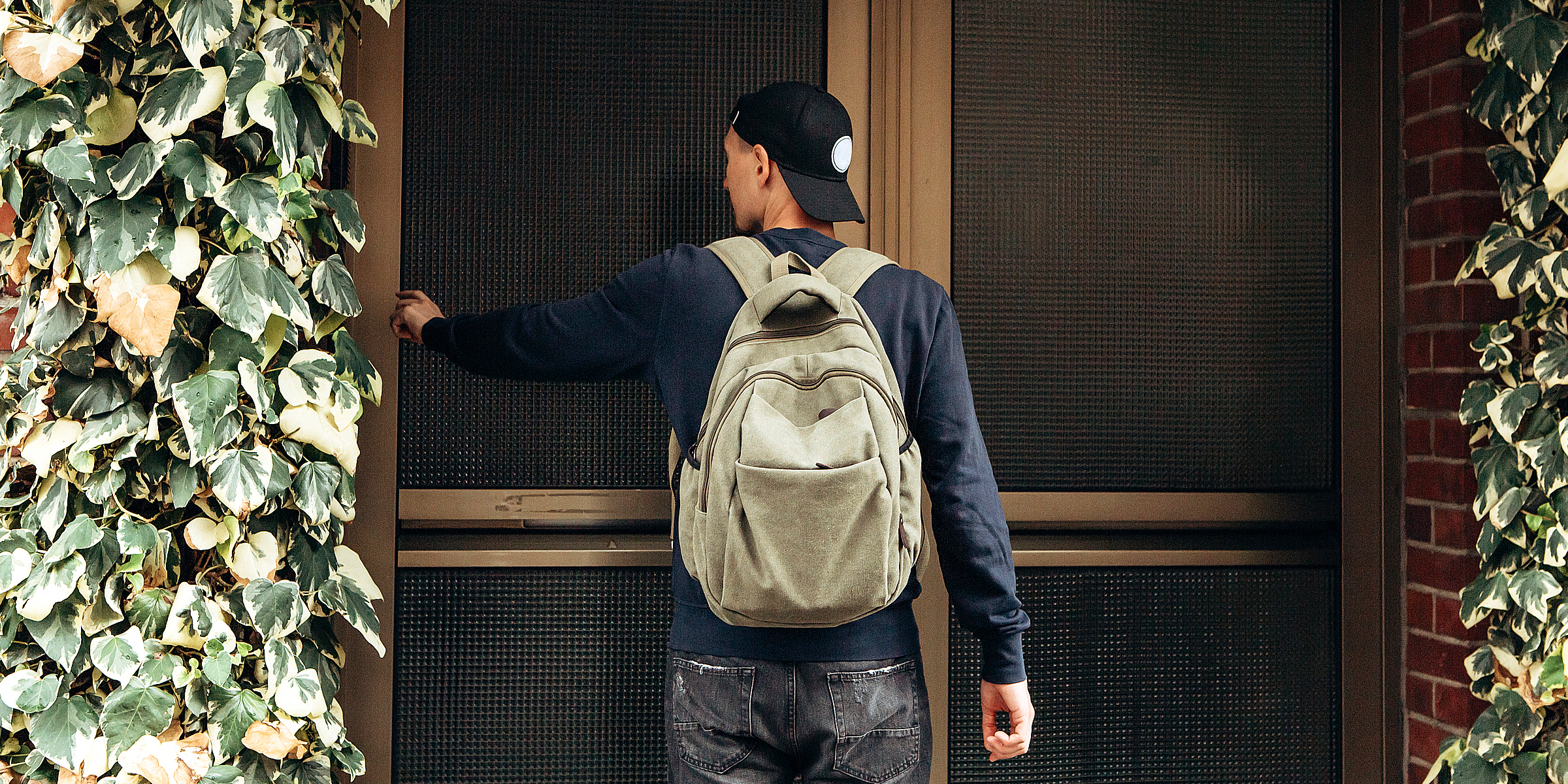 A young man with a backpack knocking on a door | Source: Shutterstock