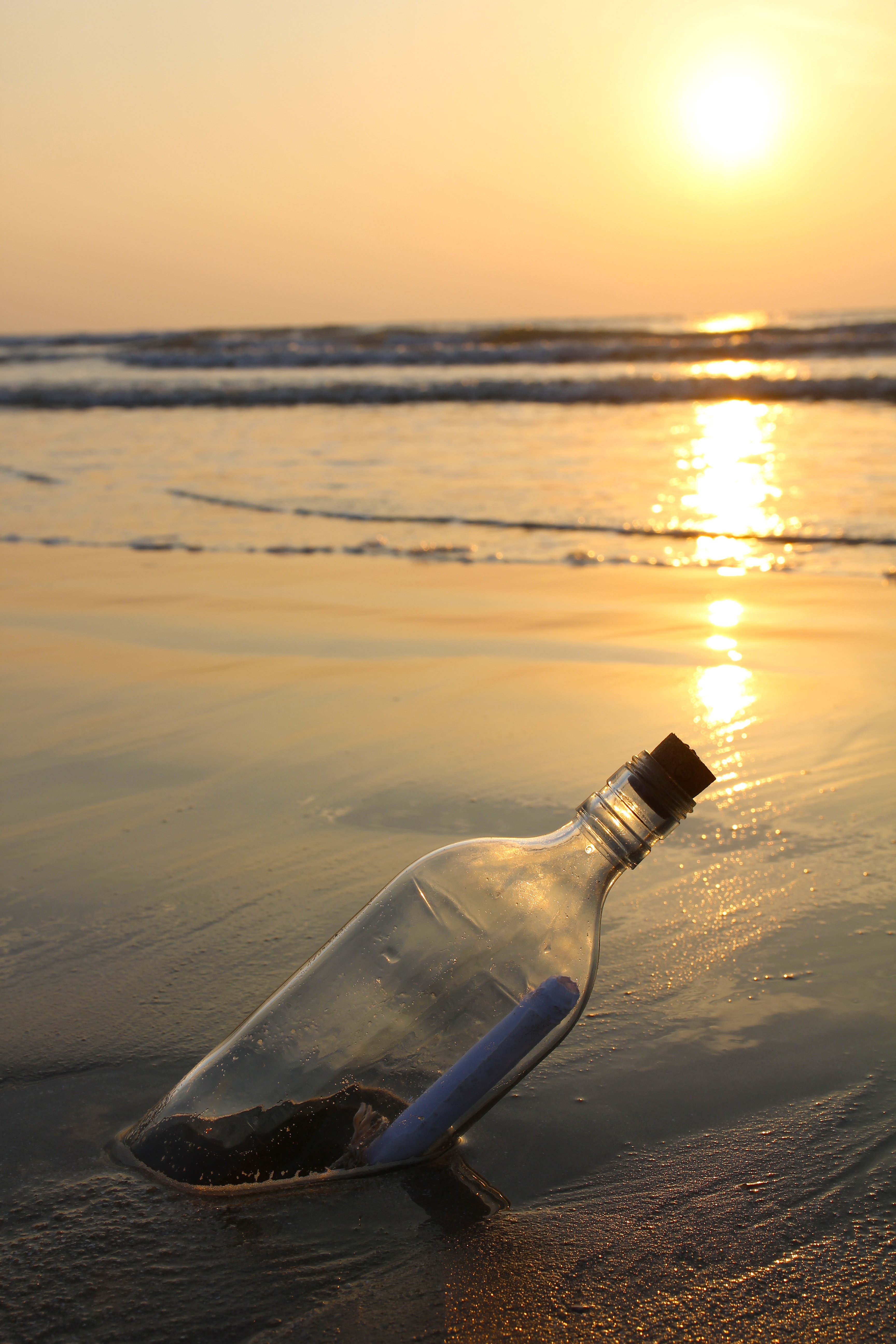 Message dans une bouteille en verre sur une plage. | Photo : Shutterstock