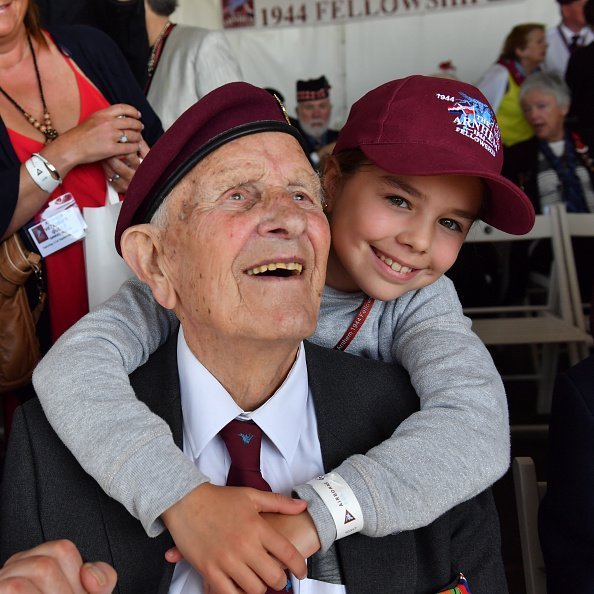 A grandpa and grandchild pictured smiling during an event | Photo: Getty Images