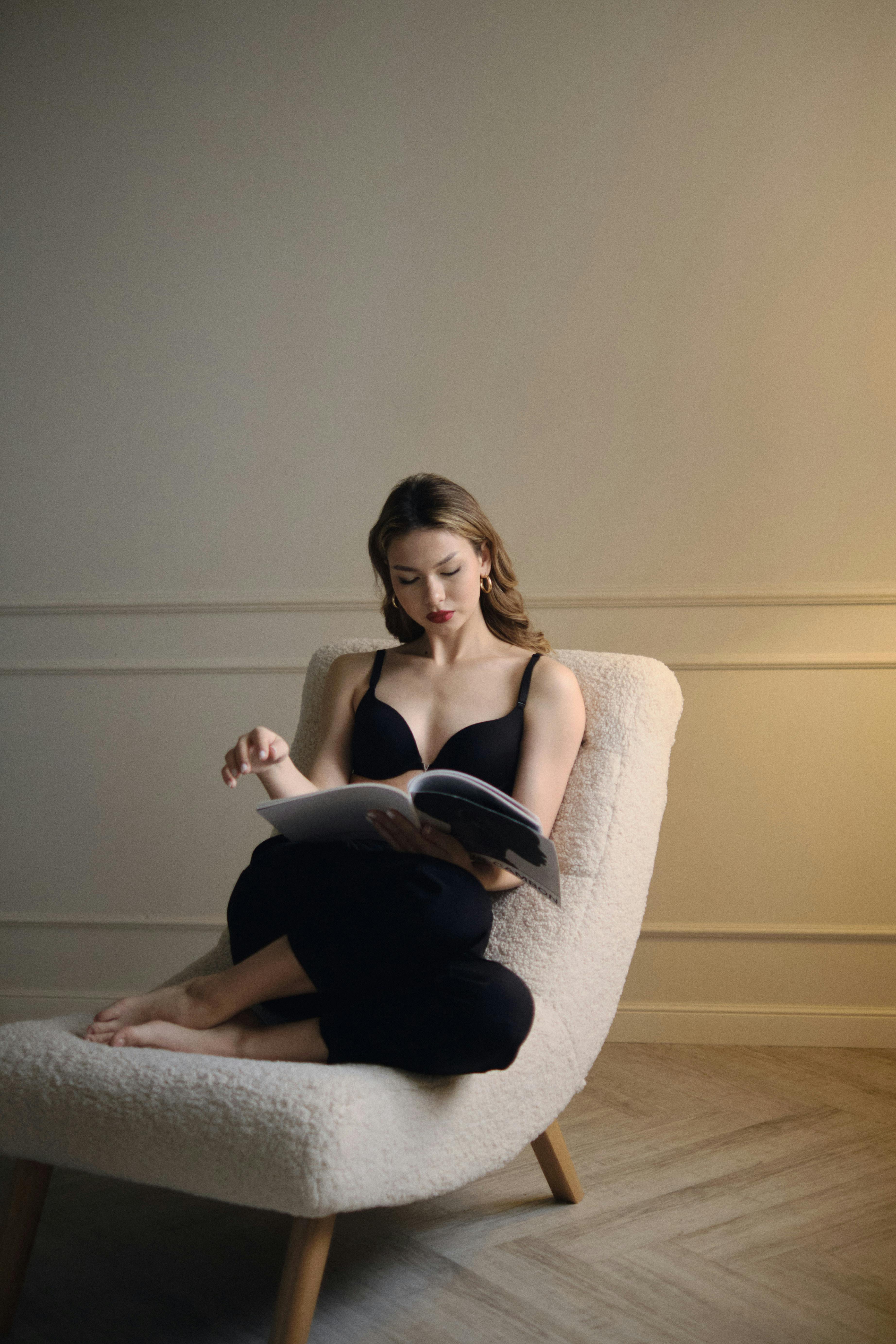 A woman reading a book on an armchair | Source: Pexels