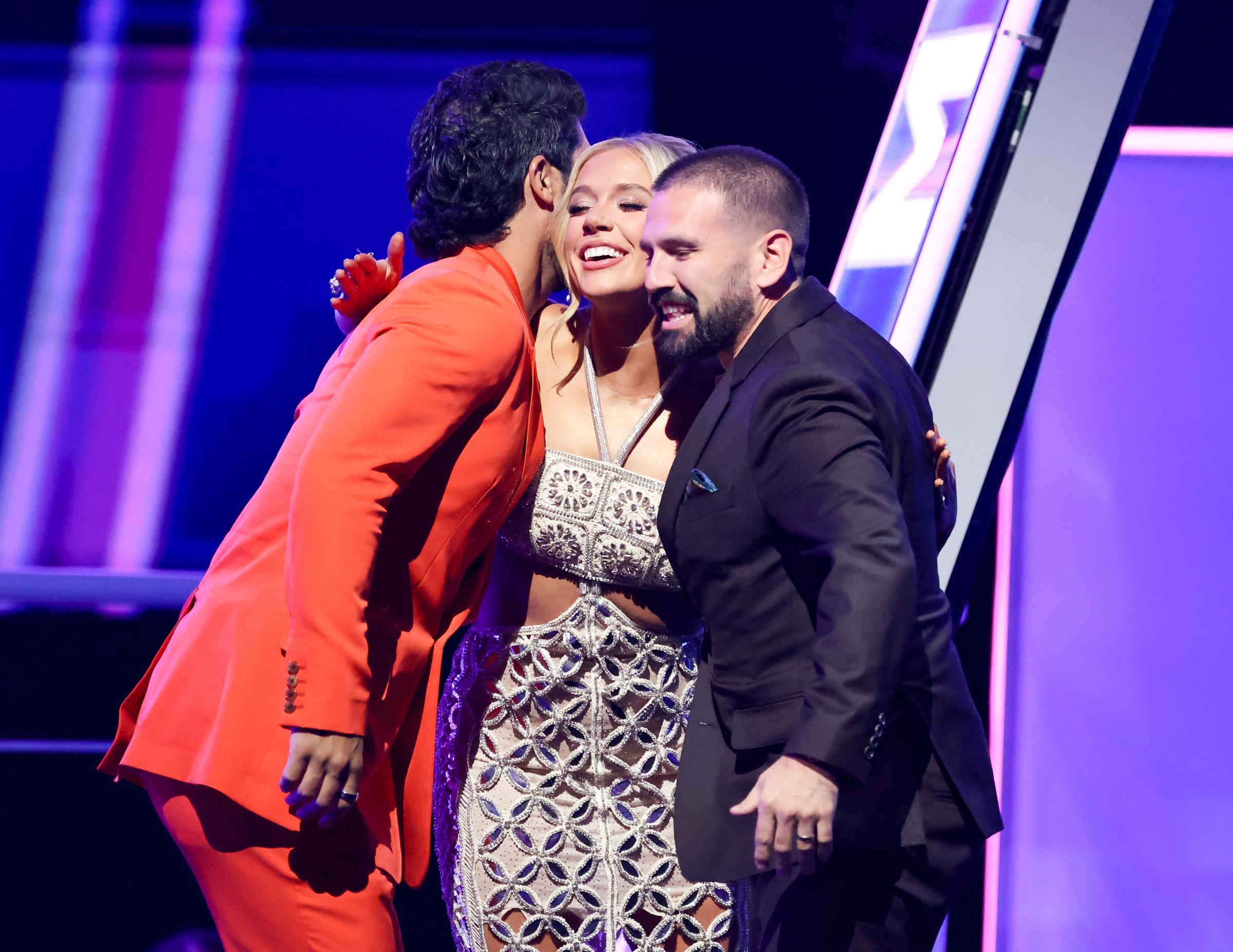 Moments after the win is announced, Moroney shares a joyful group hug on stage with awardees Dan Smyers and Shay Mooney of the band Dan + Shay, glowing with pride.