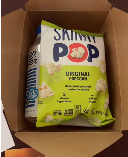 A bright green bag of SkinnyPop popcorn sits front and center, giving the snack kit a classic movie-night feel. | Source: Instagram/instylemagazine