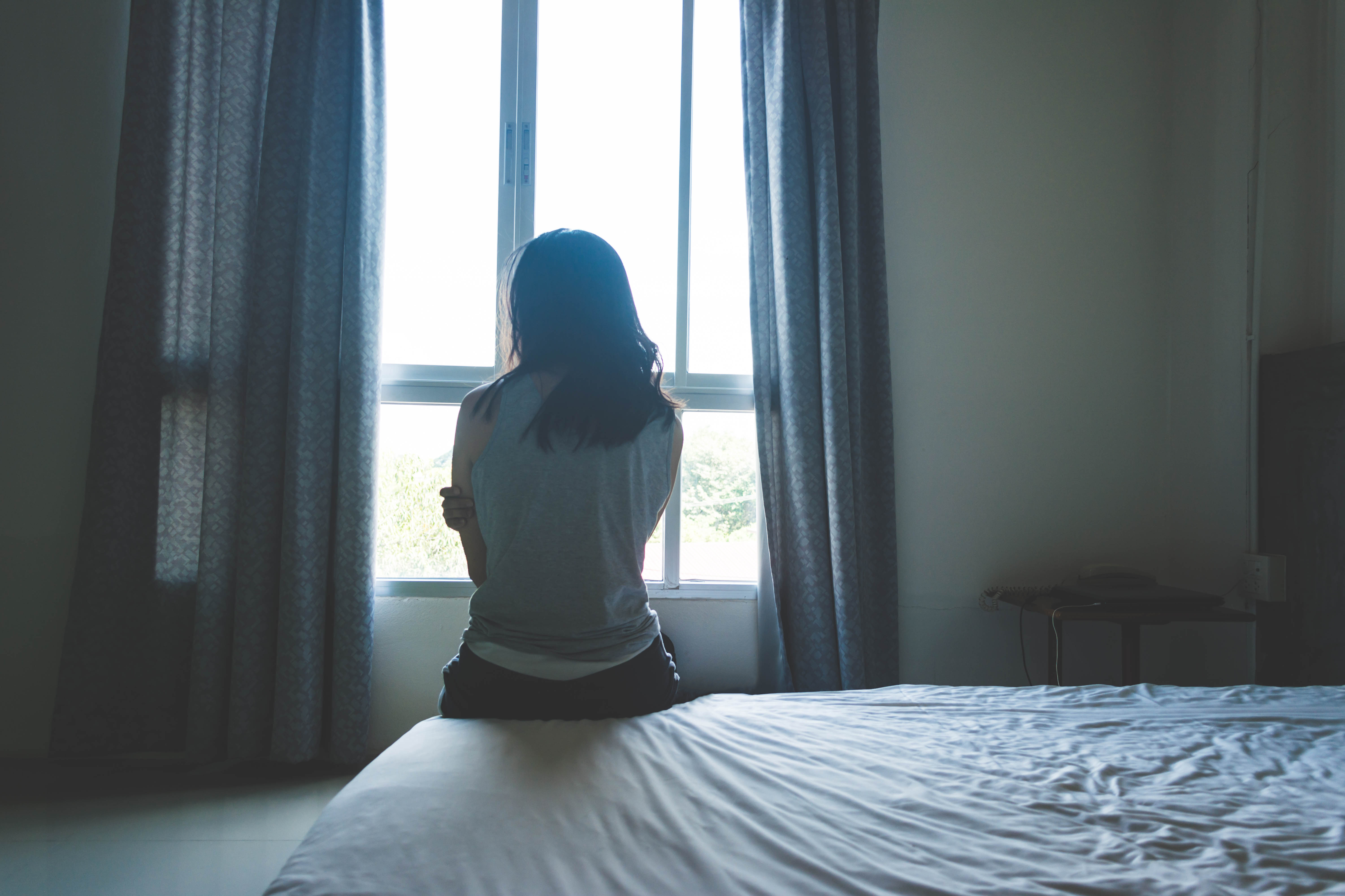 Woman sitting on bed | Source: Shutterstock