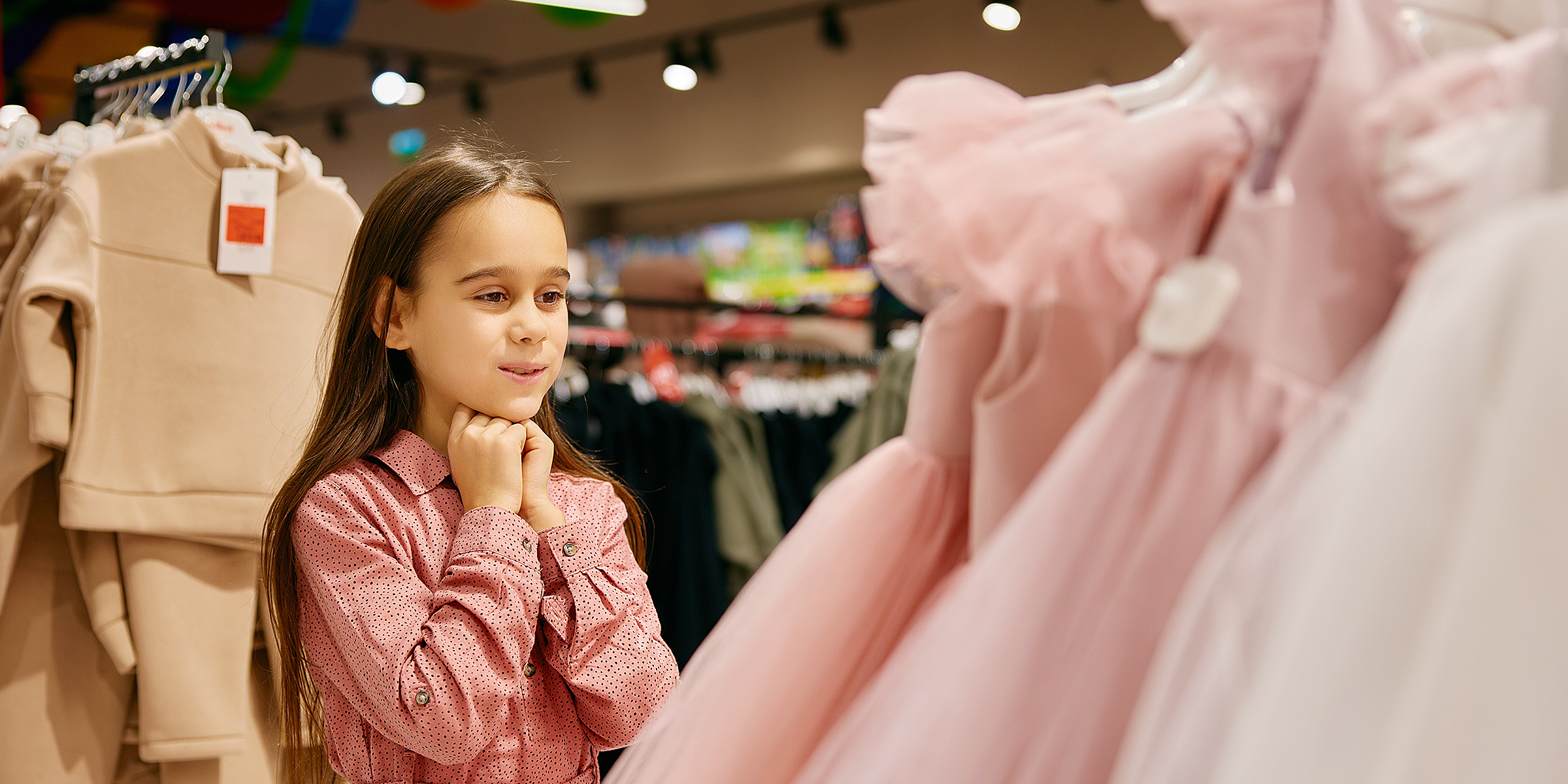 A little girl looking at a dress | Source: Shutterstock