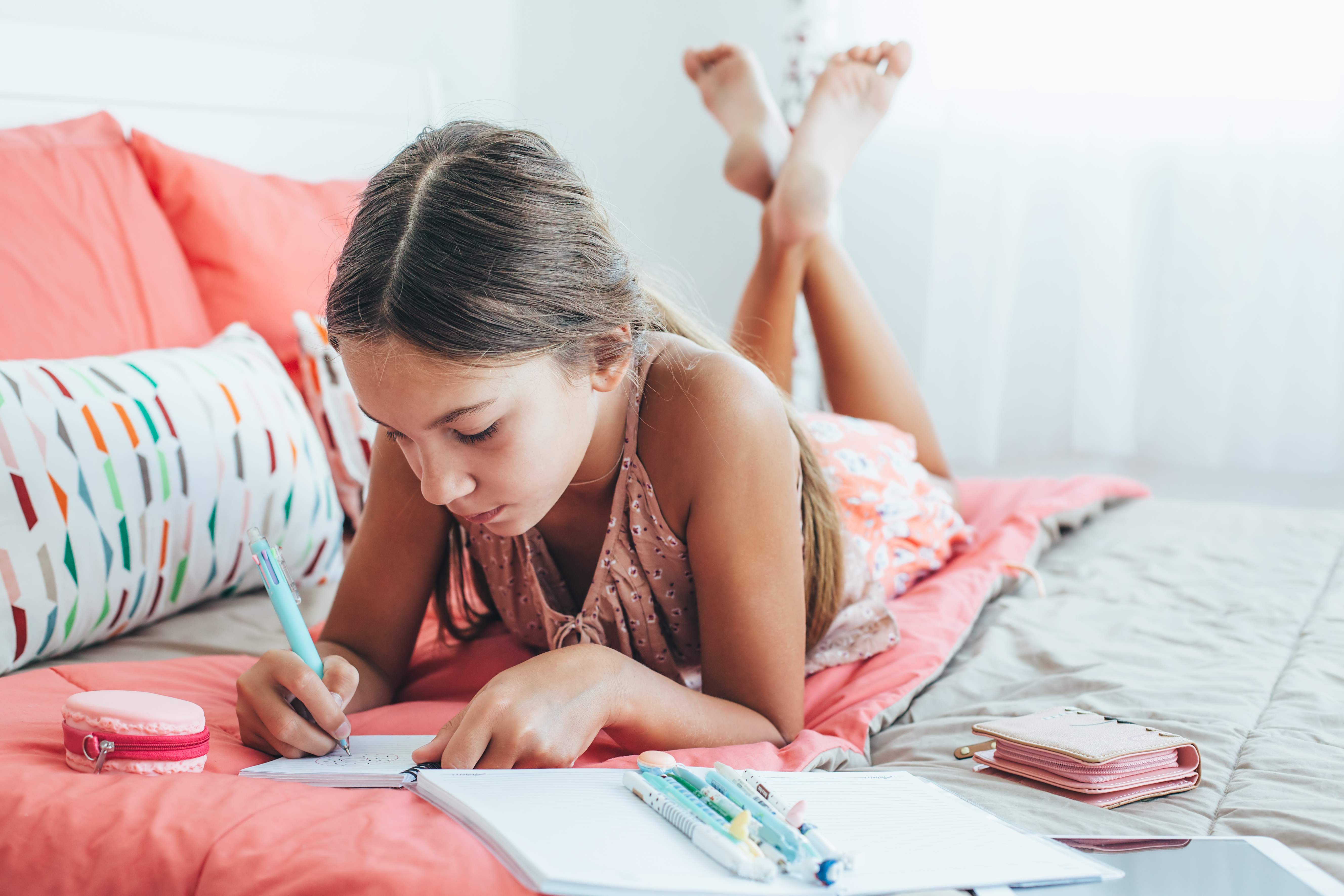A young girl is pictured writing a diary in her room | Source: Shutterstock