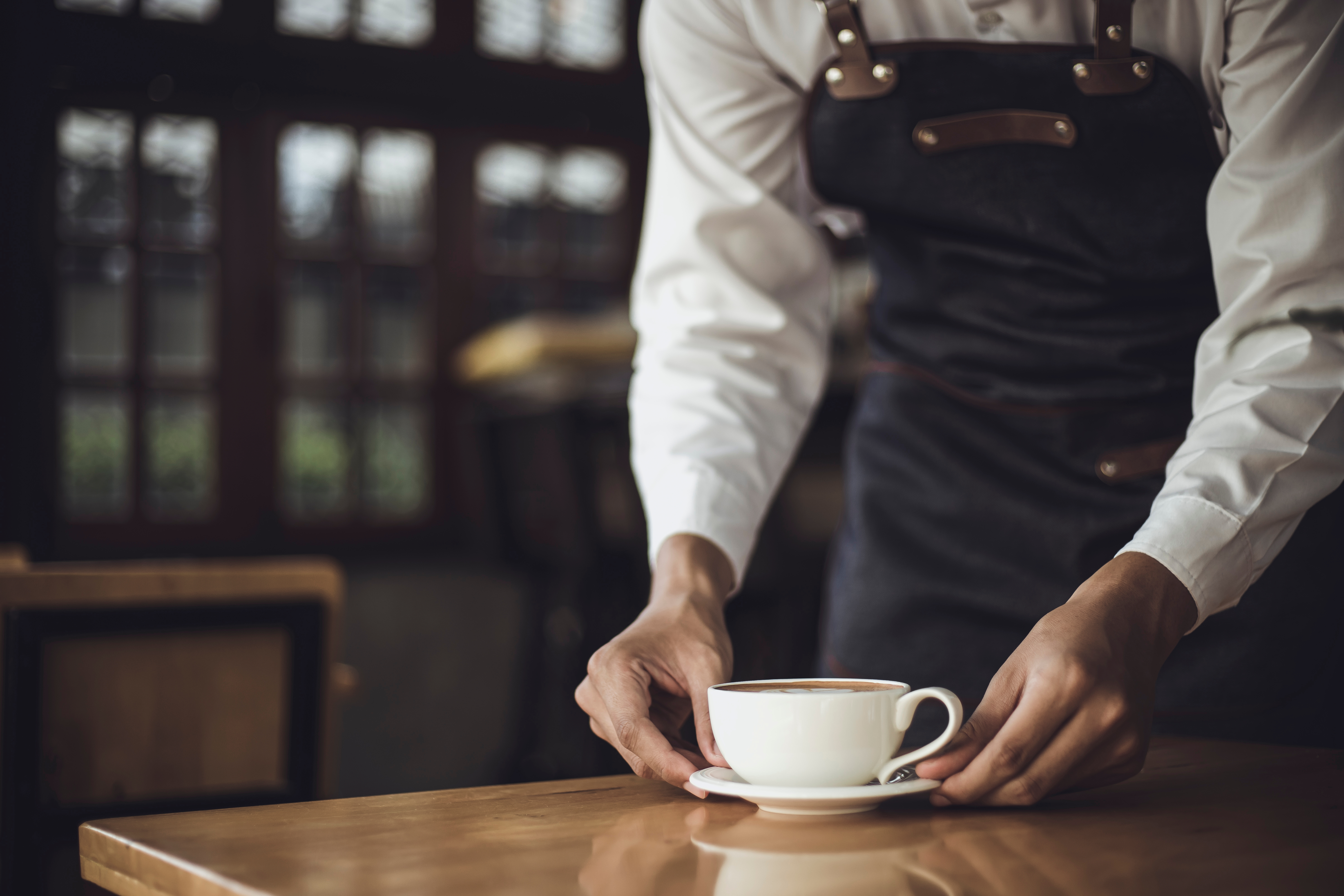 Male Barista preparing coffee for customer in coffee shop. | Source: Shutterstock