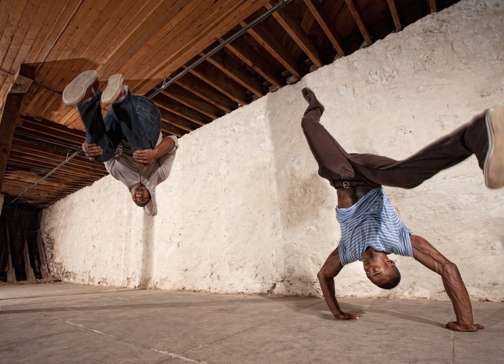 Two men doing headstands and backflips. | Photo: Shutterstock