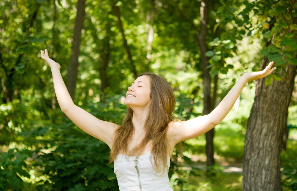 Une jolie femme riant dans les bois | Photo : Shutterstock