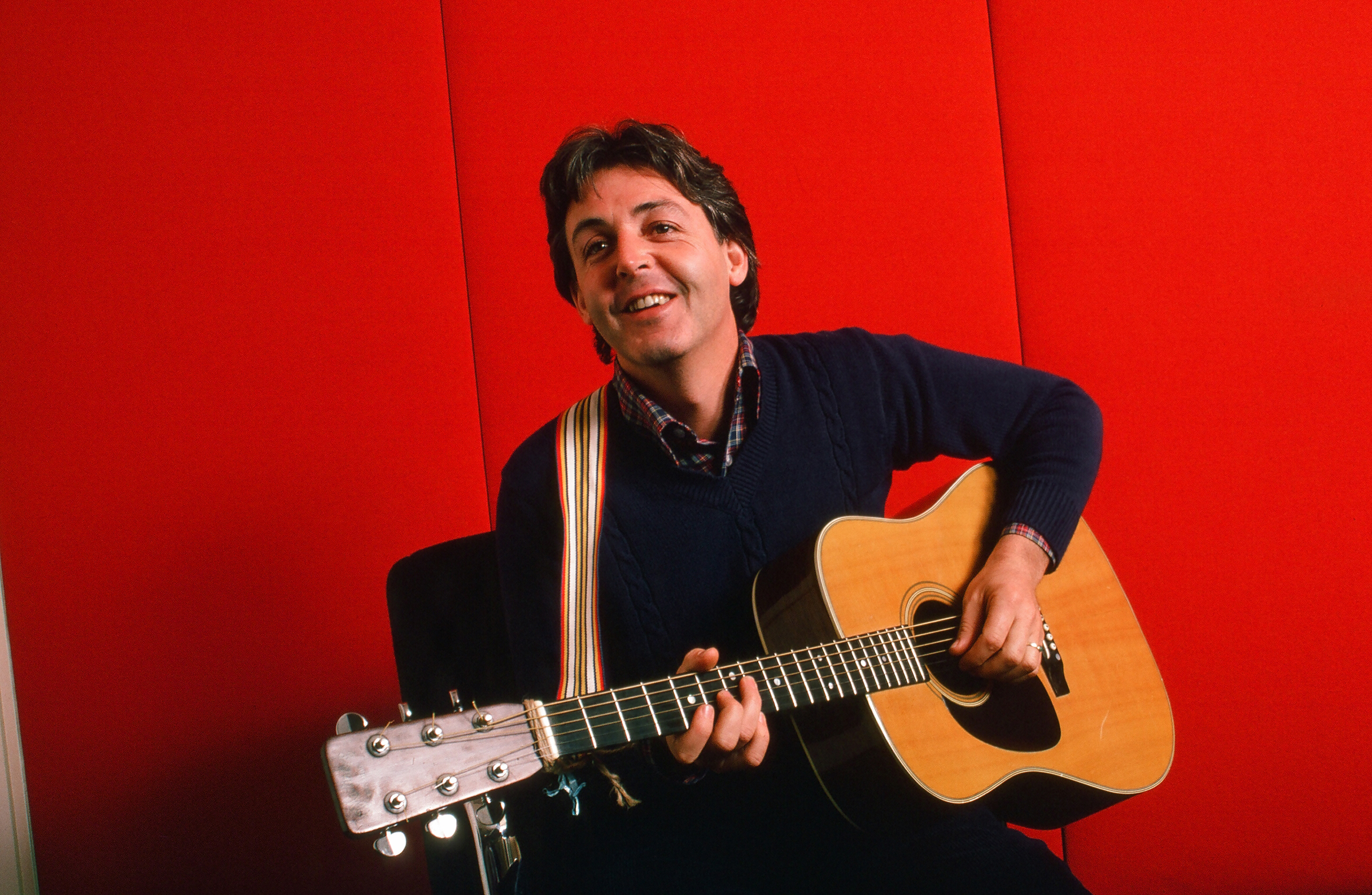 Paul McCartney as he plays acoustic guitar on October 7, 1984 | Source: Getty Images