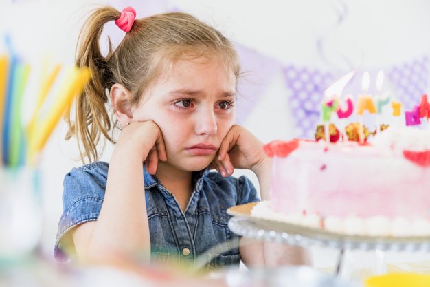 Niña triste mirando pastel / Imagen tomada de: Freepik Niña triste mirando pastel / Imagen tomada de: Freepik
