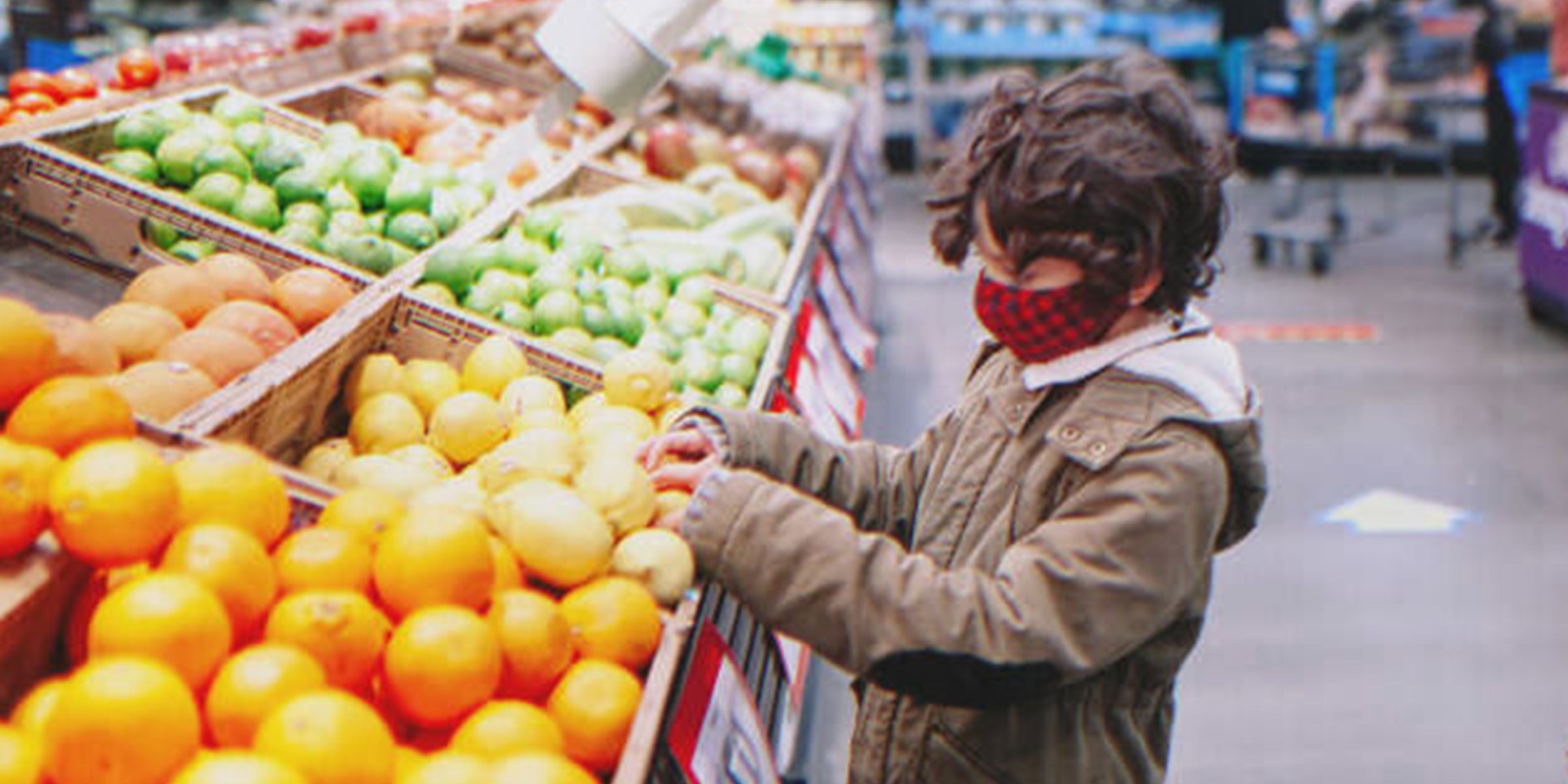 Un garçon dans un rayon de fruits et légumes | Getty Images