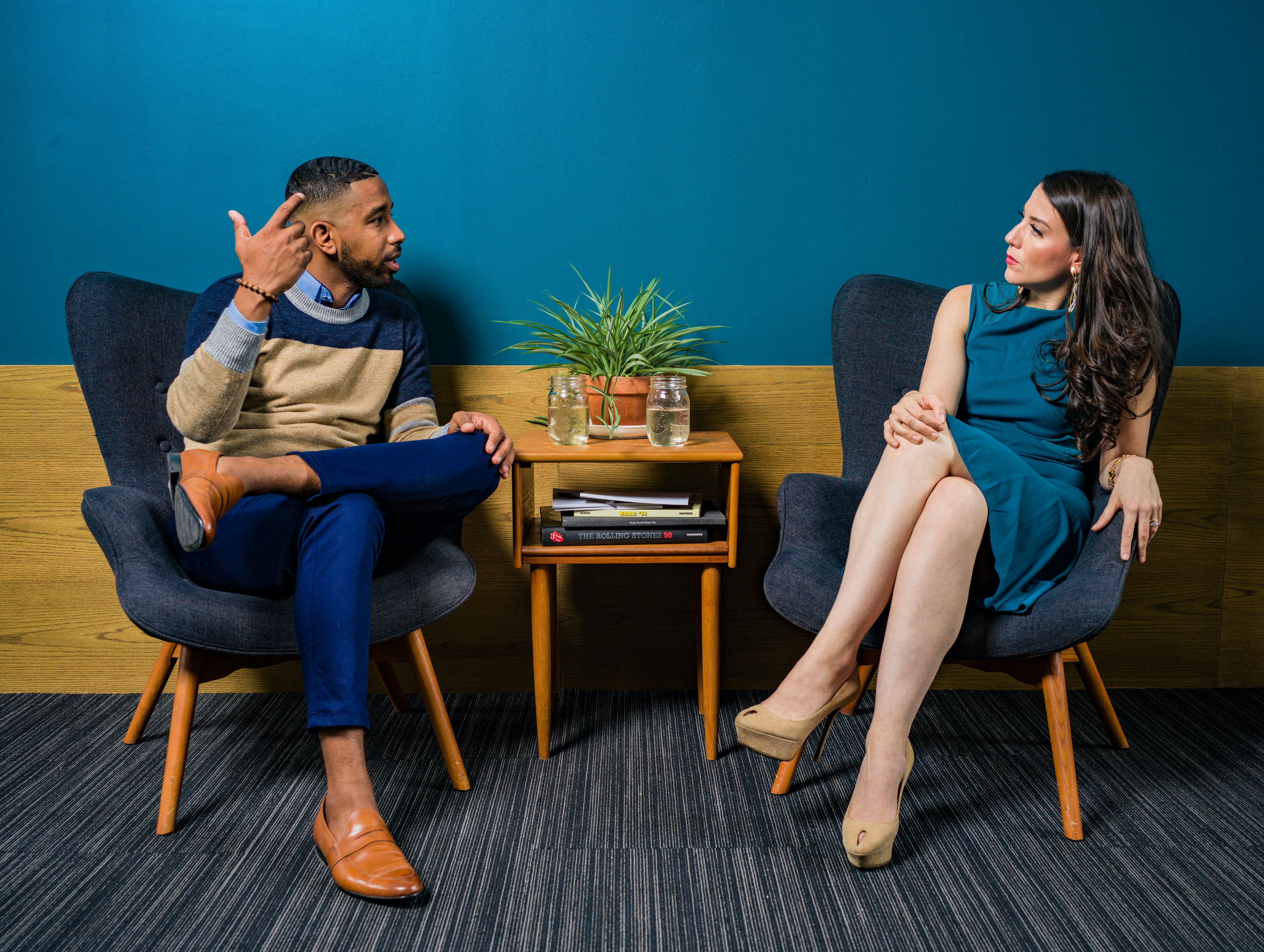 Two people sitting on opposite sides of a table while having a heated conversation | Source: Pexels