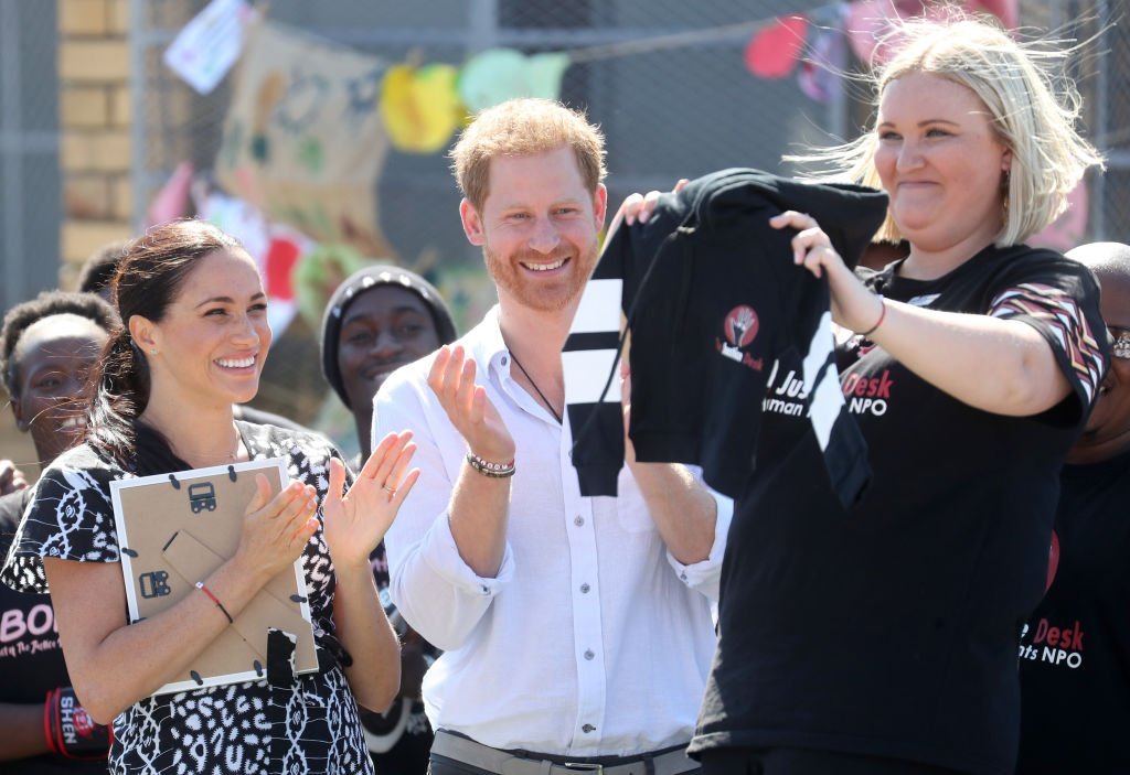 Meghan Markle and Prince Harry laugh with Jessica Dewhurst, Justice Desk Founder  during their visit to a Justice Desk initiative in Nyanga township. | Source: Getty Images