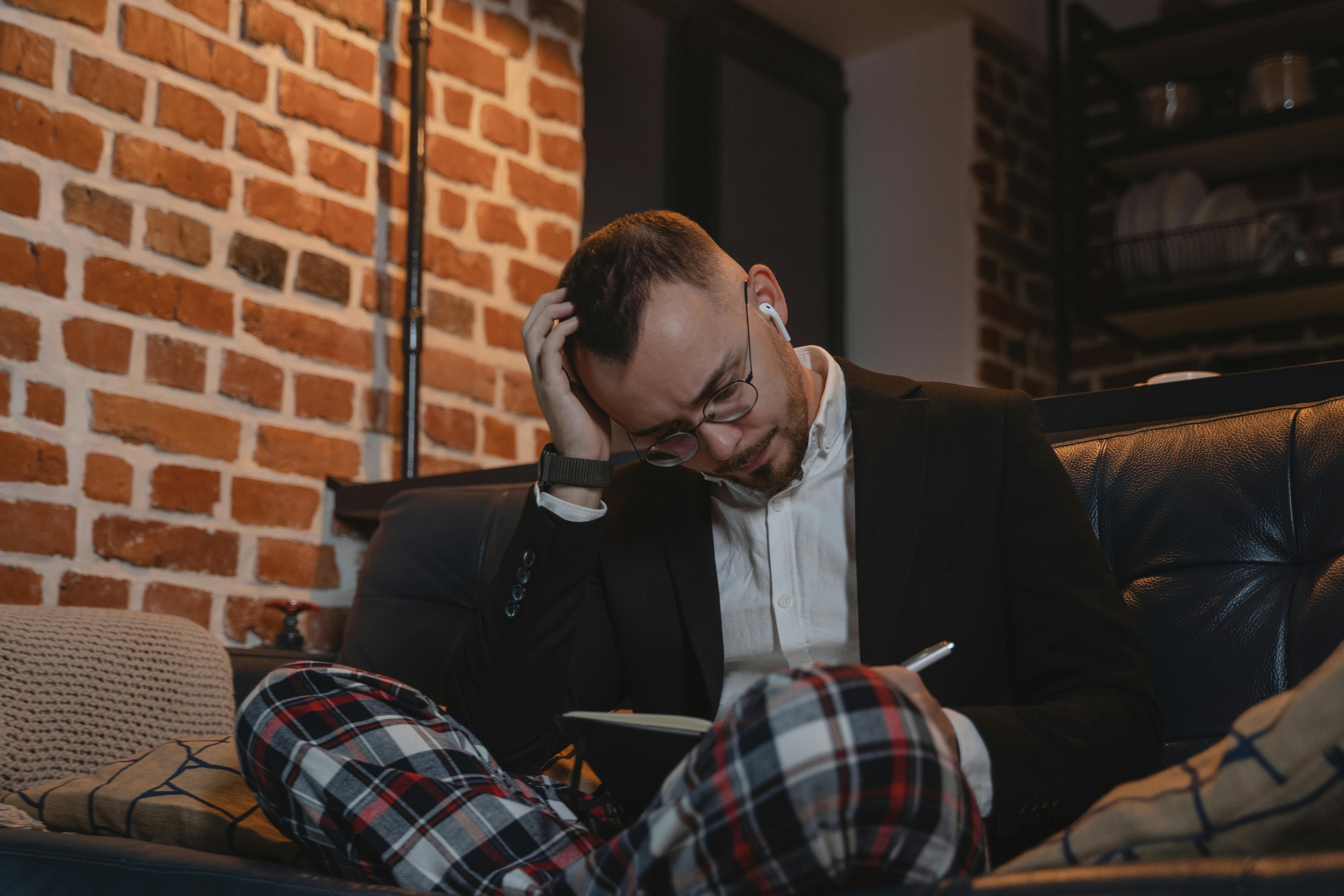 Stressed man sitting on the couch | Source: Unsplash