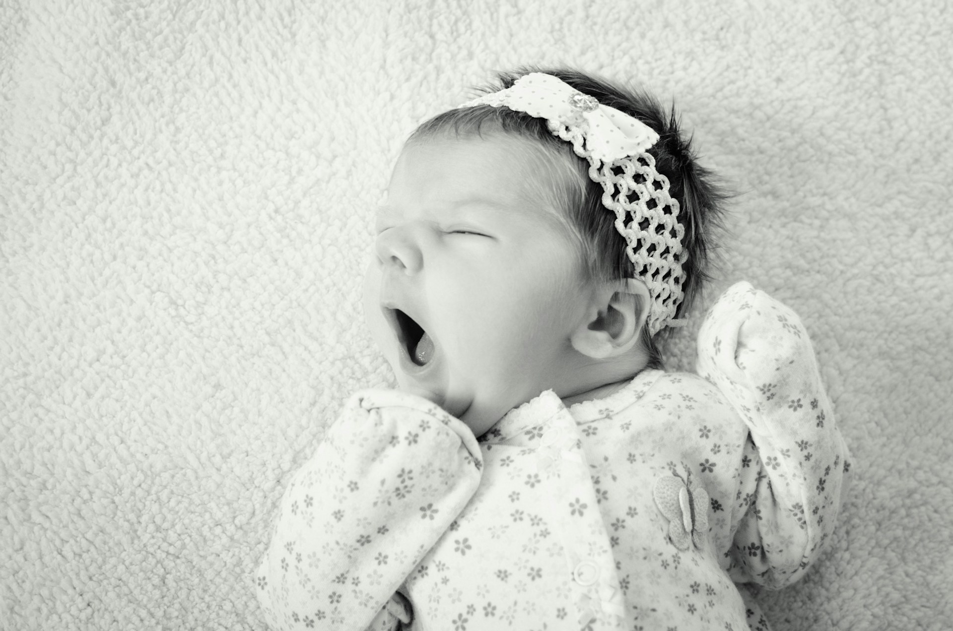 Grayscale shot of an adorable baby girl | Source: Unsplash