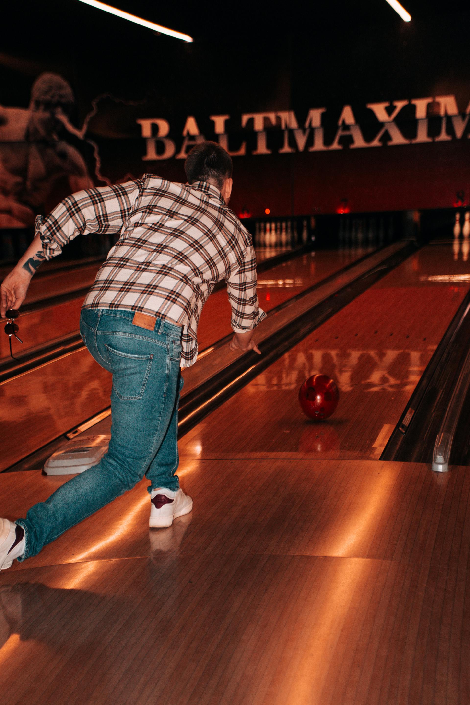 A back view of a man throwing a ball in a bowling alley | Source: Pexels