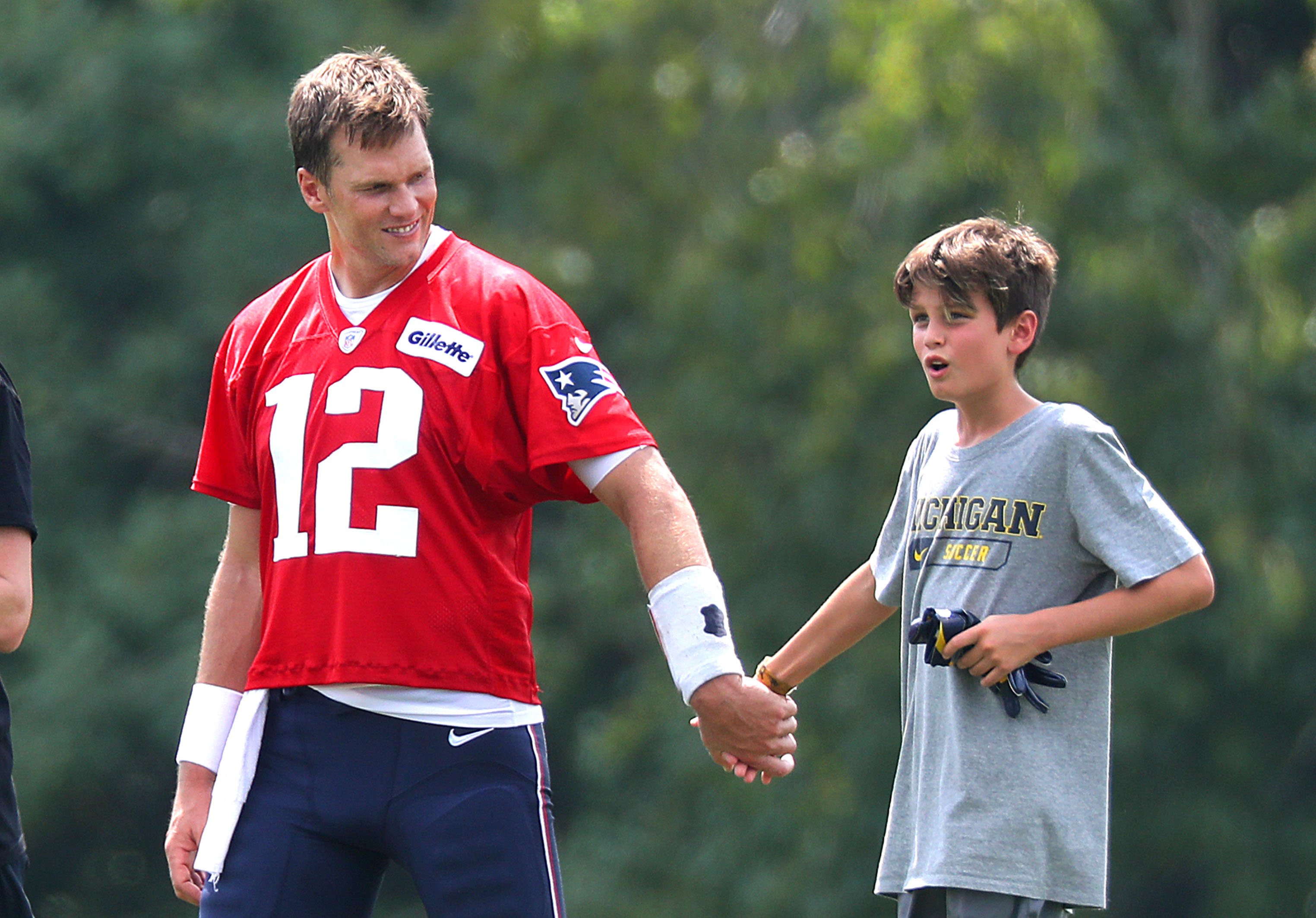 Tom Brady walking off the field with his son, Jack after New England Patriots training camp at the Gillette Stadium practice facility on August 7, 2018 in Foxborough, Massachusetts ┃Source: Getty Images