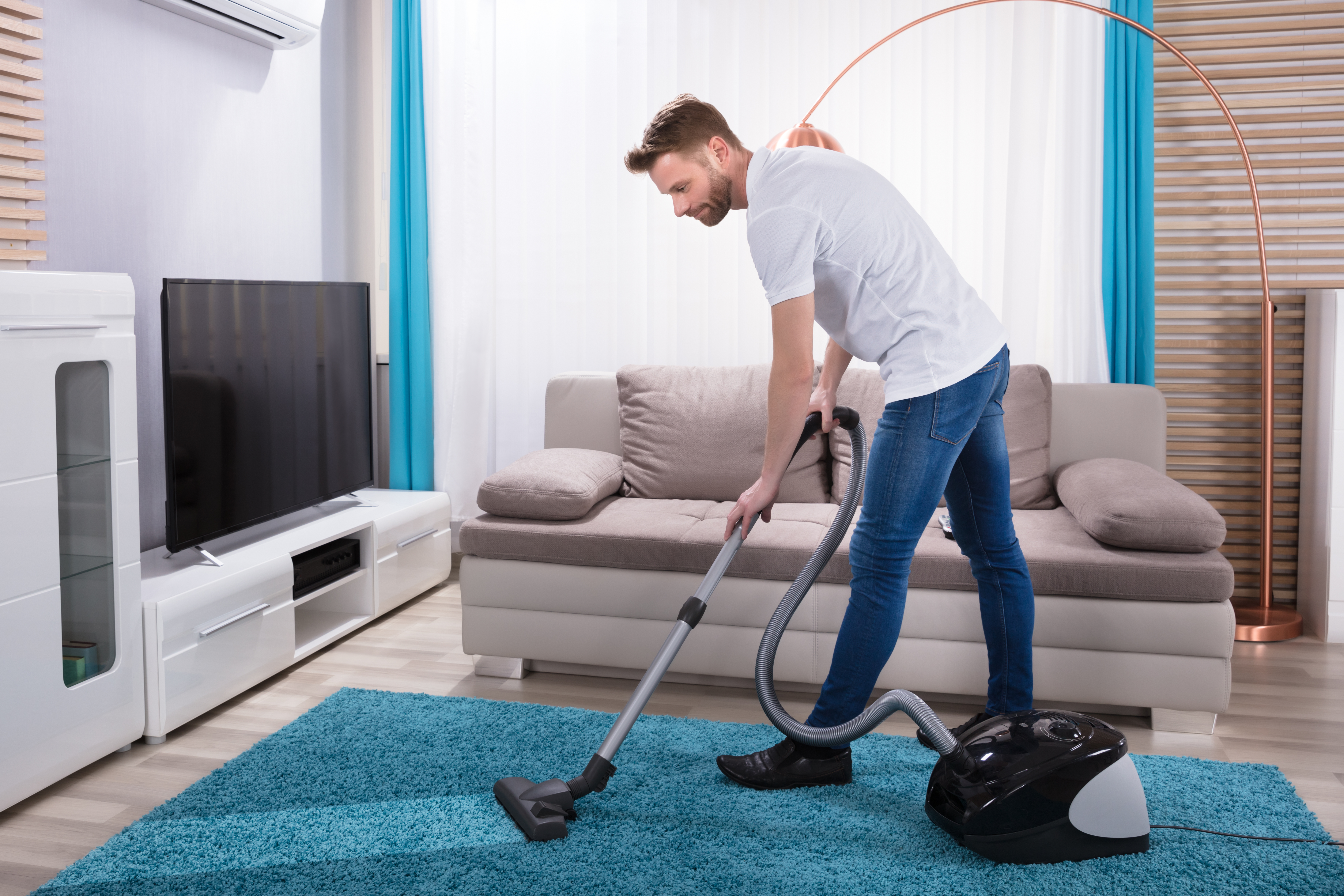 A man using a vacuum cleaner | Source: Shutterstock
