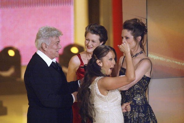 Tony Curtis (l) smiles as he flanked by his daughters Alexandra Sergeant (l-r), Allegra and Kelly Curtis after receiving the "Honorary Award" at the Goldene Kamera Film Awards at the Gendarmenmarkt Concert House on February 4, 2004 in Berlin, Germany. Curtis was given an "Honorary Award" for his contribution to the film industry. | Source: Getty Images.