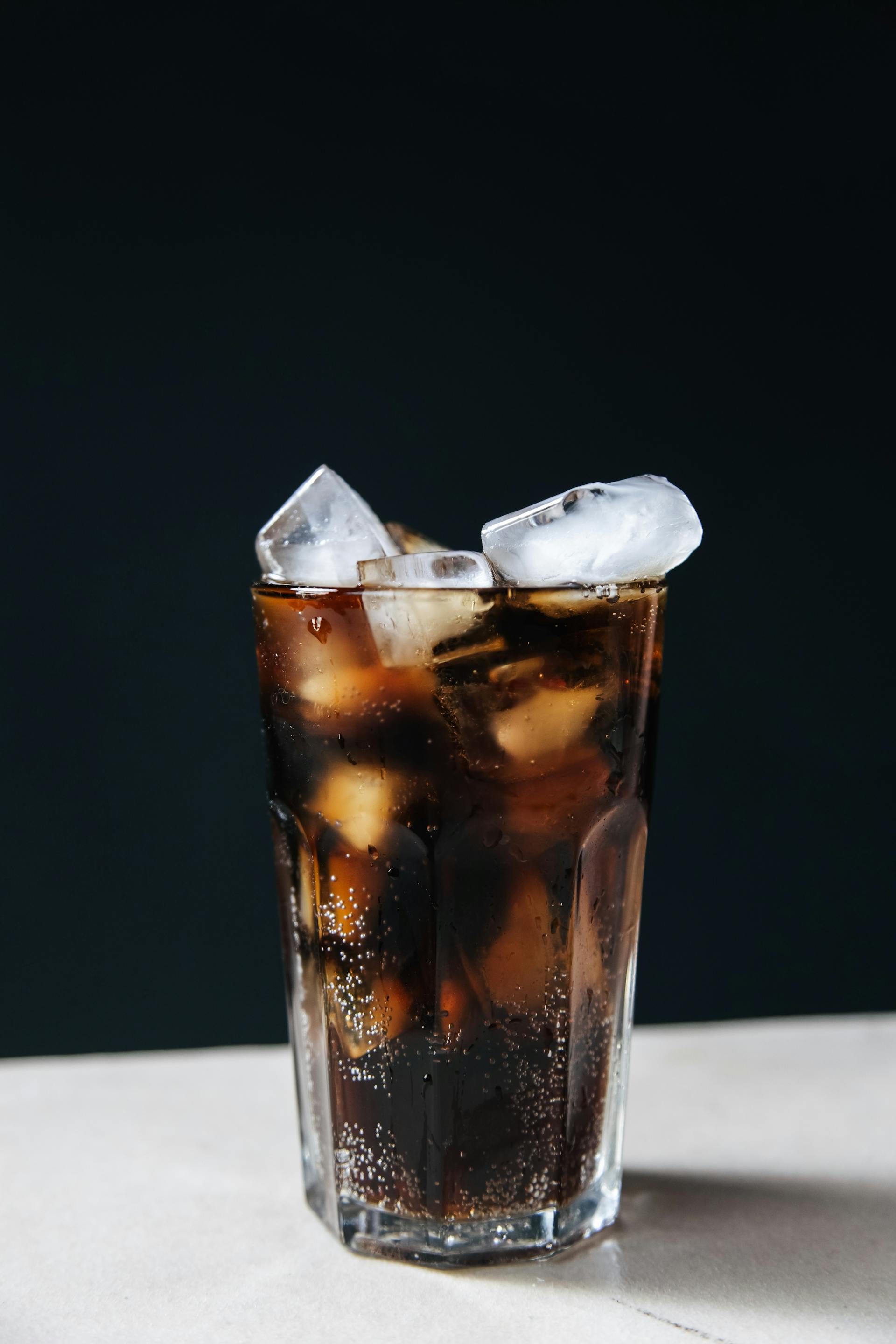 A glass of iced cola on a table | Source: Pexels