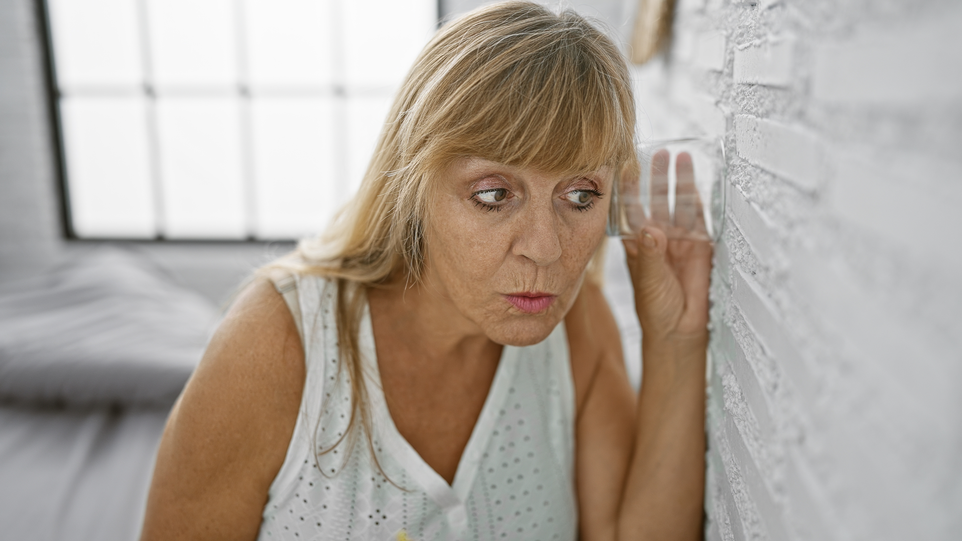 A middle-aged woman eavesdropping | Source: Shutterstock