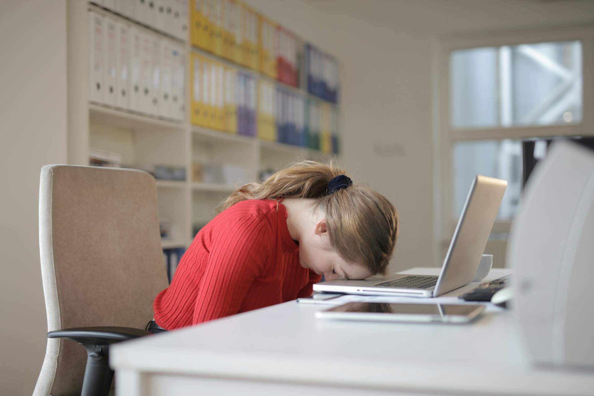 A woman putting her head on her desk | Source: Pexels