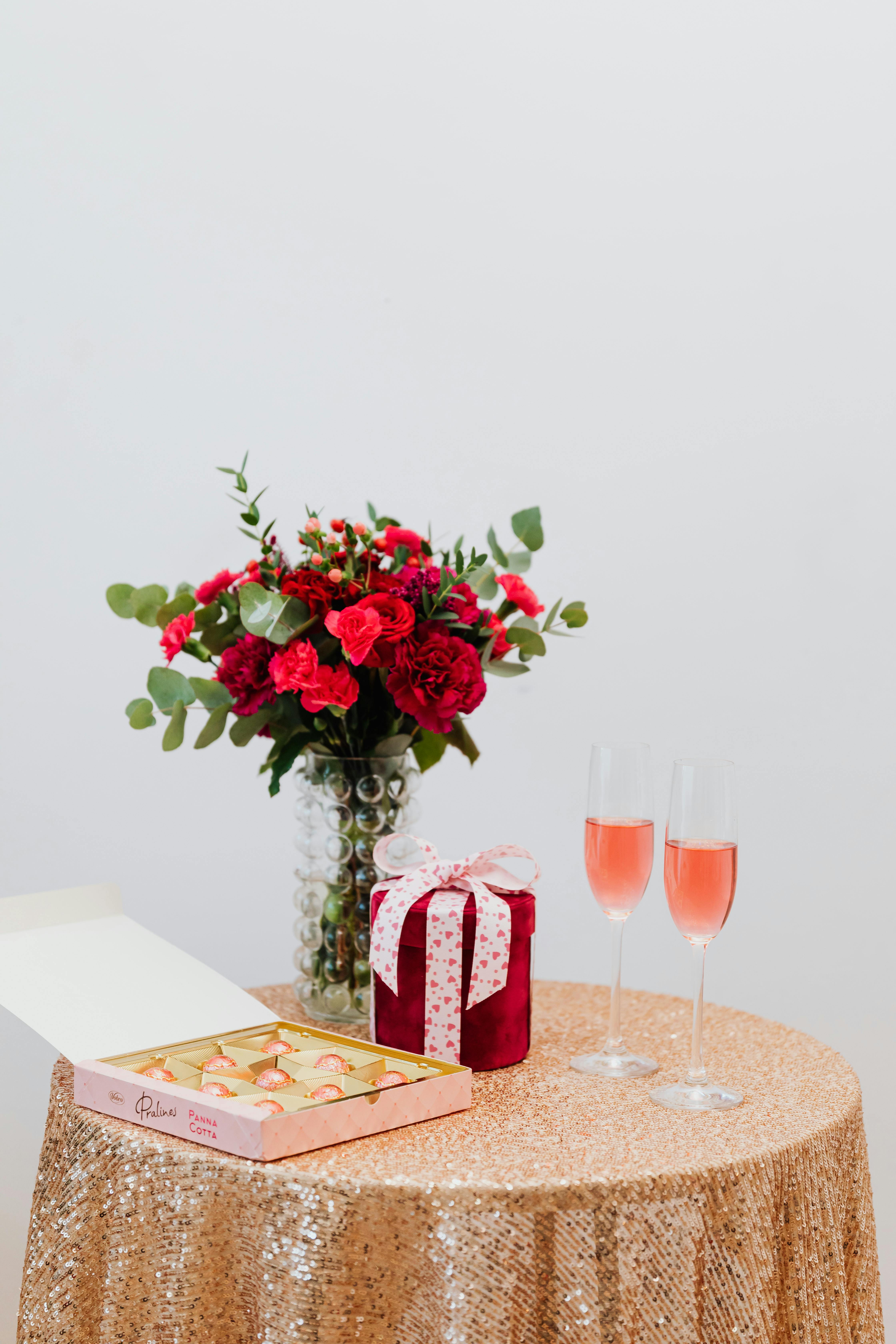 Flowers, Chocolates, a Gift and Glasses of Champagne on a Table | Source: Pexels