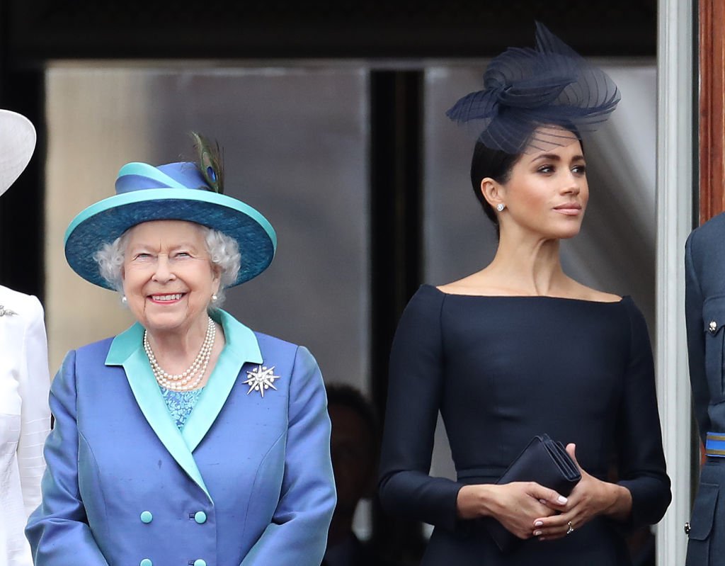 la reine Elizabeth II et Meghan, duchesse de Sussex sur le balcon du palais de Buckingham en tant que famille royale assister à des événements pour marquer le centenaire de la RAF le 10 juillet 2018 à Londres, en Angleterre. | Photo : Getty Images