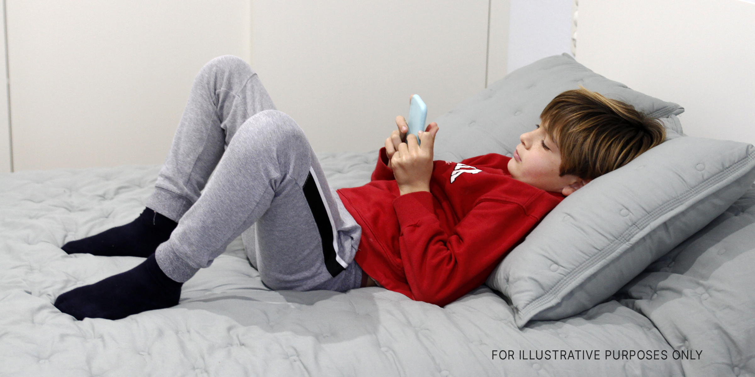 A boy using his phone on the sofa | Source: Getty Images