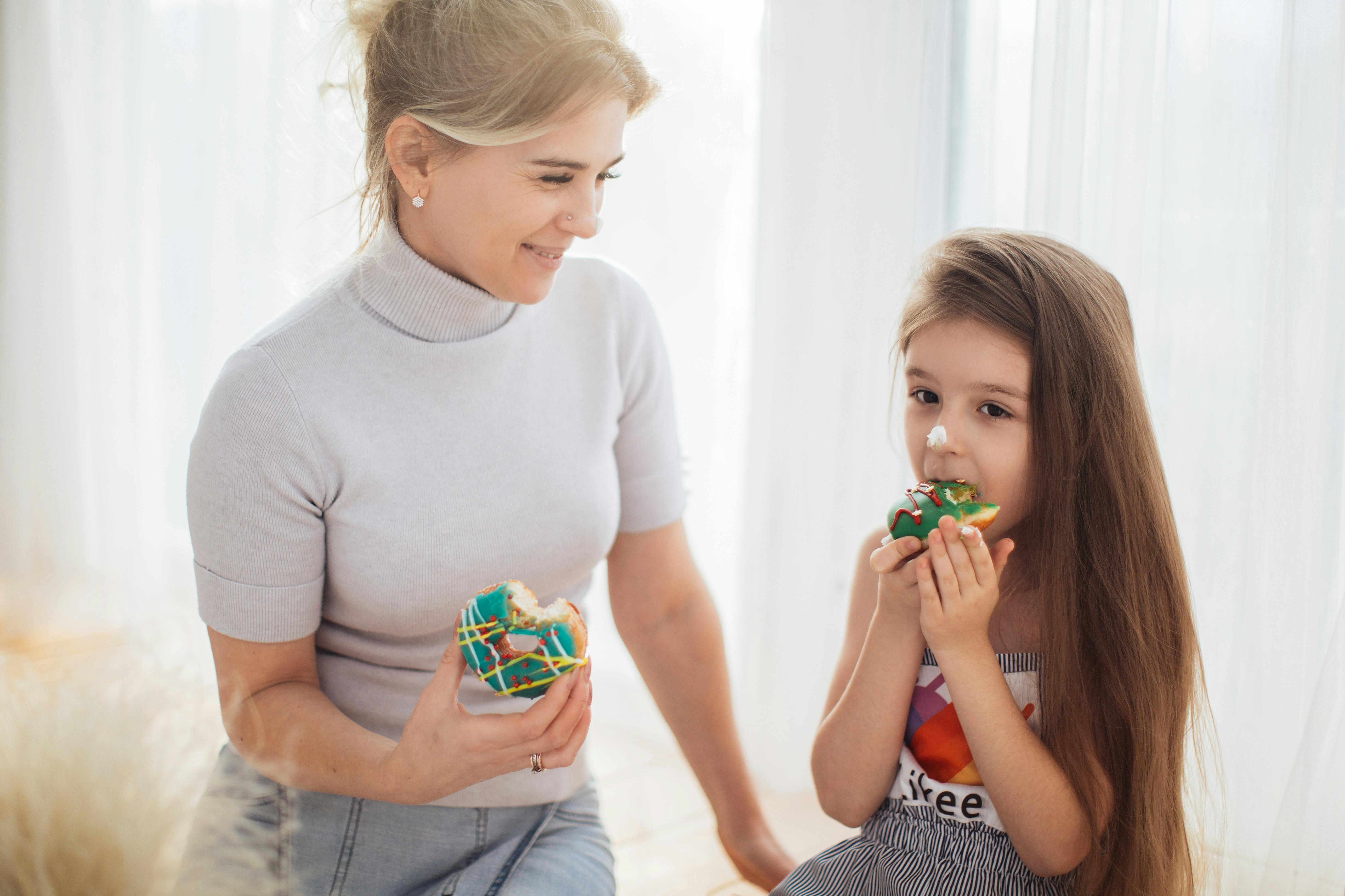 A mother and daughter enjoying donuts | Source: Pexels