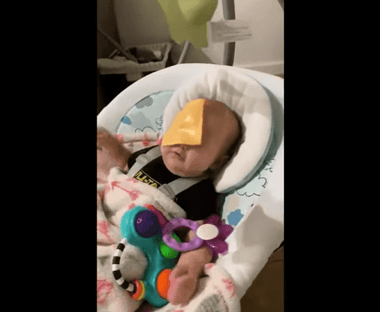 A baby with a slice of cheese stuck to his face | Photo: TopVids!