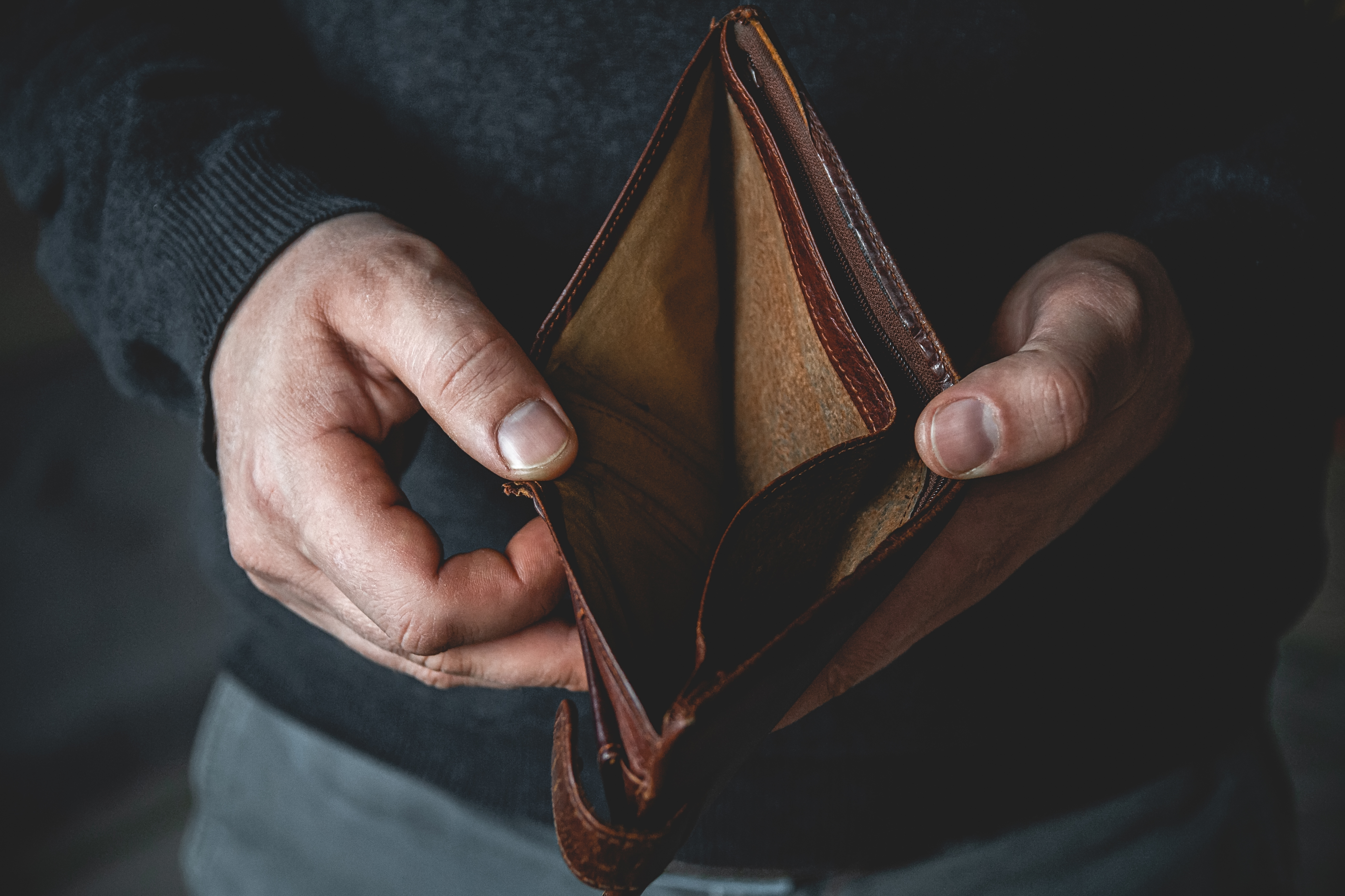 A man holding an empty wallet | Source: Shutterstock