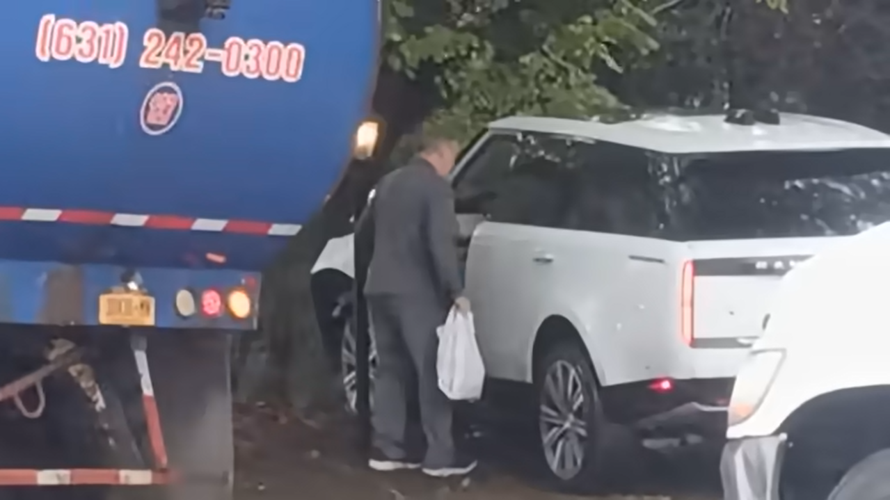 A garbage truck is seen at the scene of the crash, beside the totaled SUV, from a video dated October 14, 2025 | Source: YouTube/@nypost
