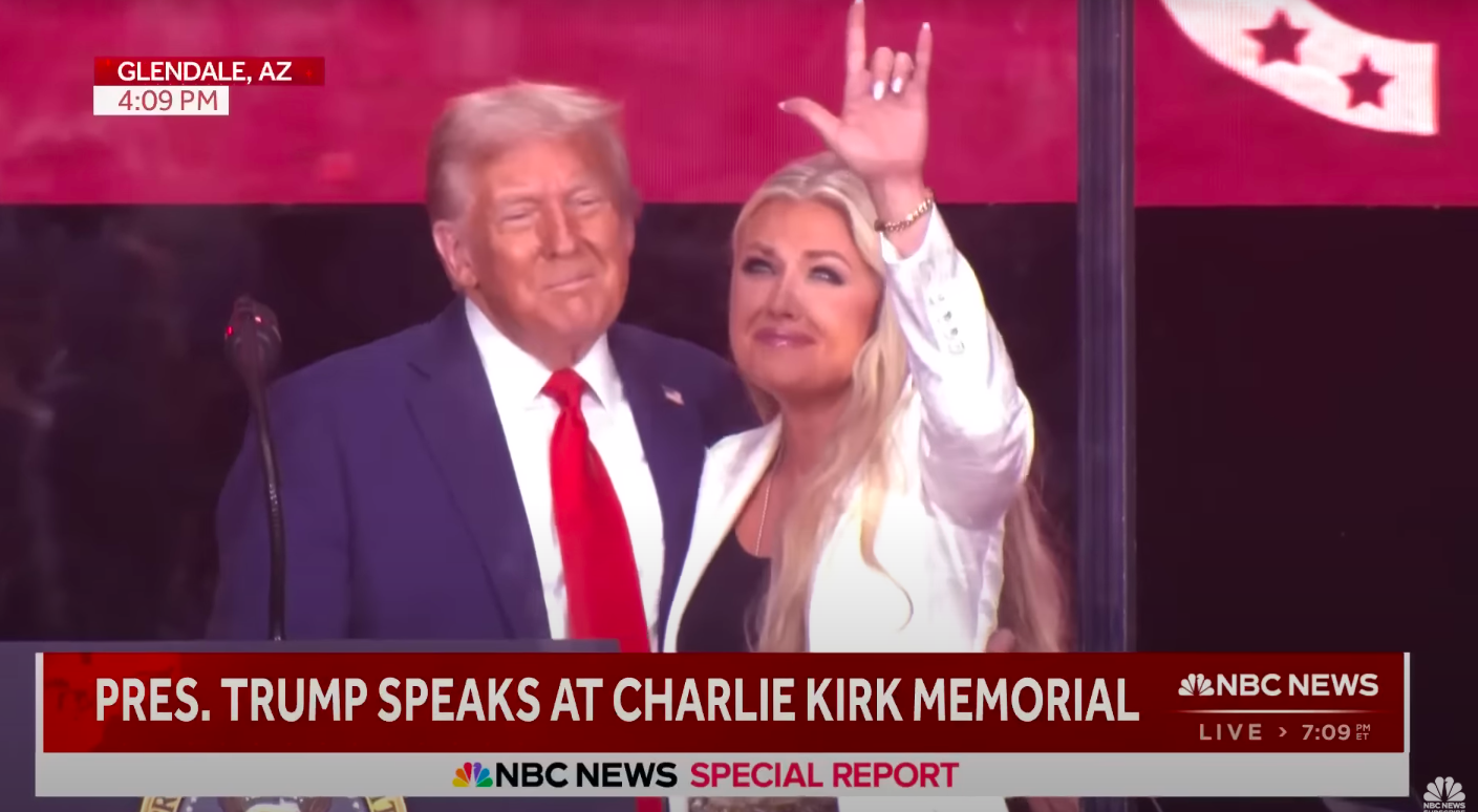 Erika Kirk gesturing the hand signal as Donald Trump looks on. | Source: YouTube/NBC News